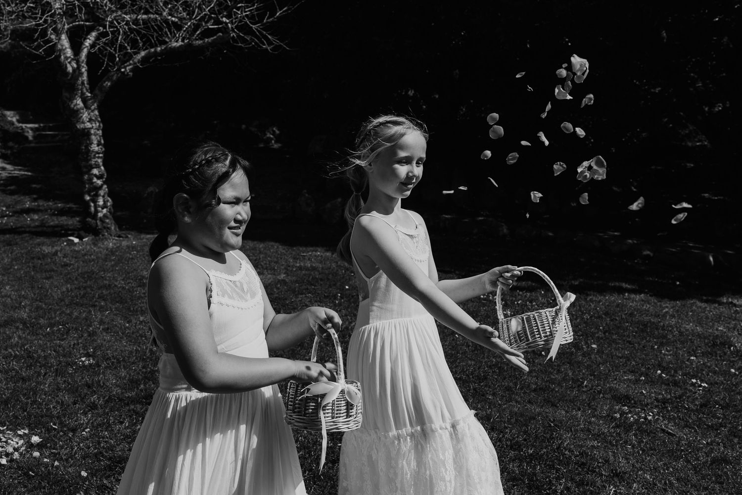 A wedding party poses together outdoors in elegant black and white attire.