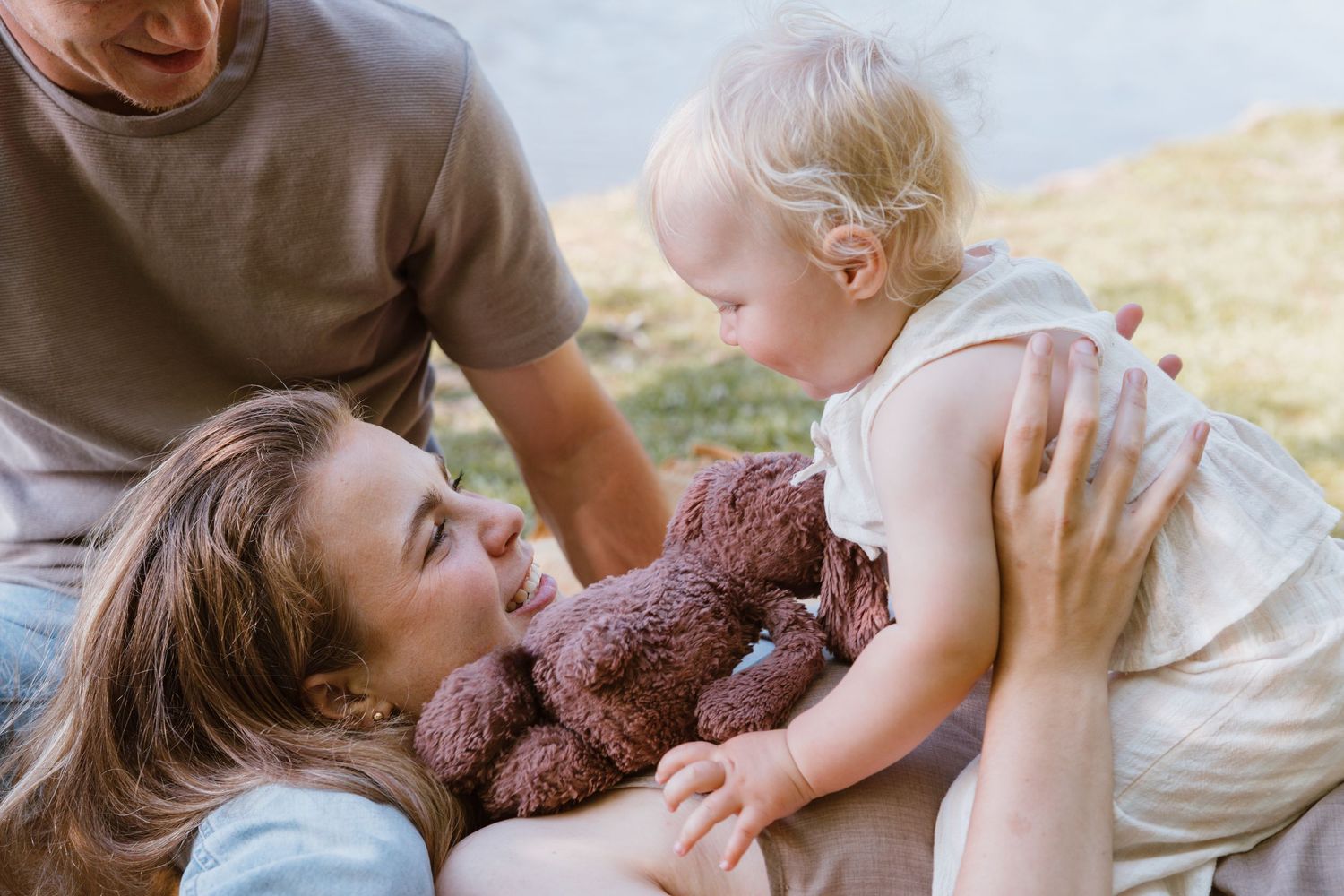 Parent and child share tender moments playing with a teddy bear in a series of candid photos.