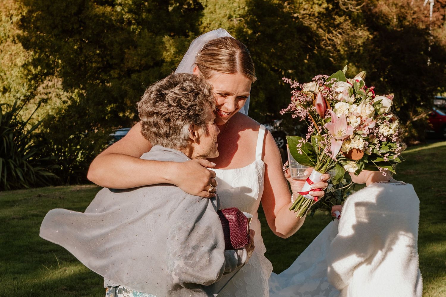 Bride and groom share intimate moments during an outdoor wedding celebration surrounded by nature and flowers.