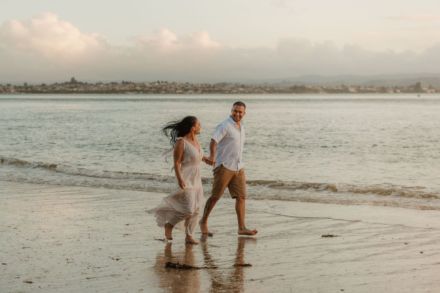 Couple enjoying a romantic moment together while exploring a sandy beach at sunset.