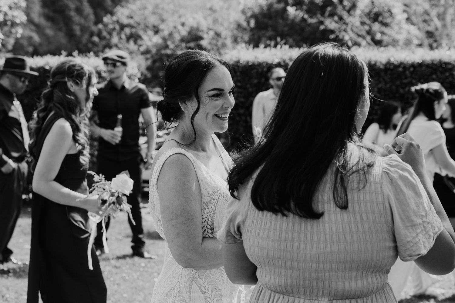 Group of wedding guests dancing and celebrating together on an outdoor dance floor during a black and white reception.