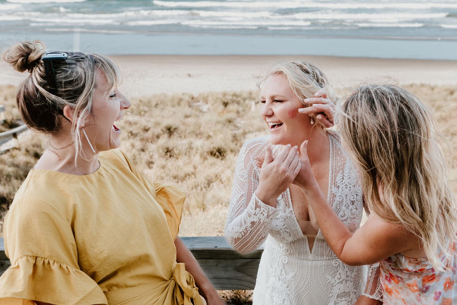 Candid wedding party photos on a breezy beach with flowing dresses and natural lighting. Papamoa Beach Wedding