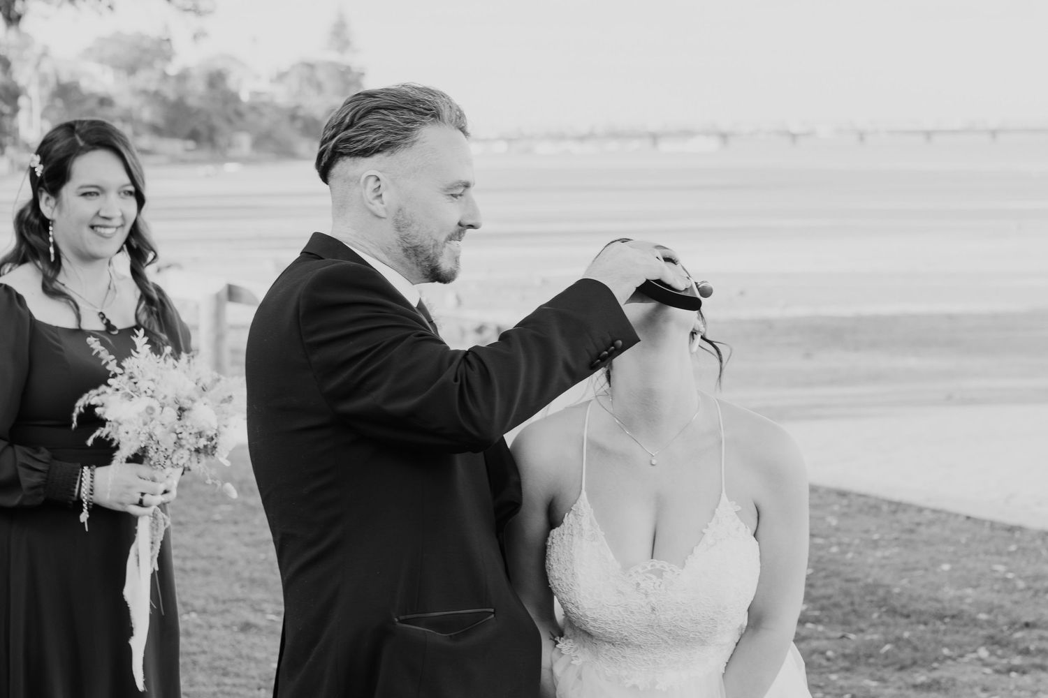 Black and white wedding photos showing joyful moments near a scenic outdoor landscape.