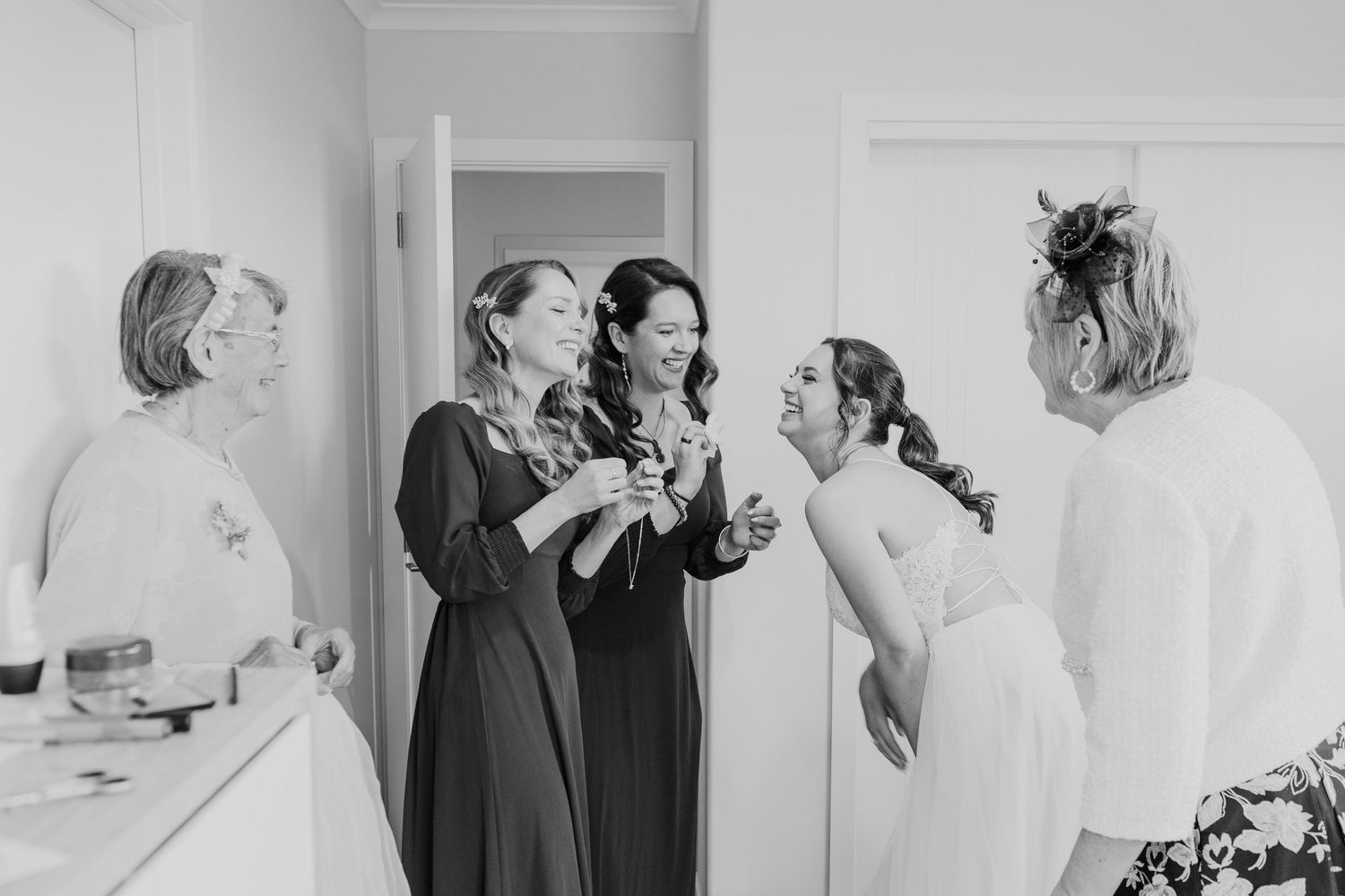 People preparing backstage with hair and makeup being done while wearing black and white outfits.