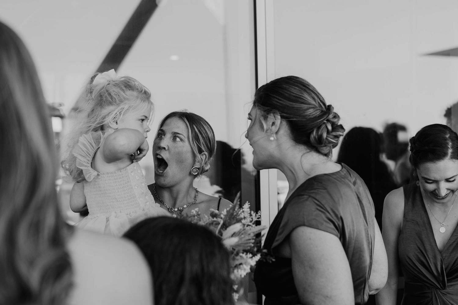 Black and white photo showing a candid moment of laughter and joy during a social gathering or celebration.