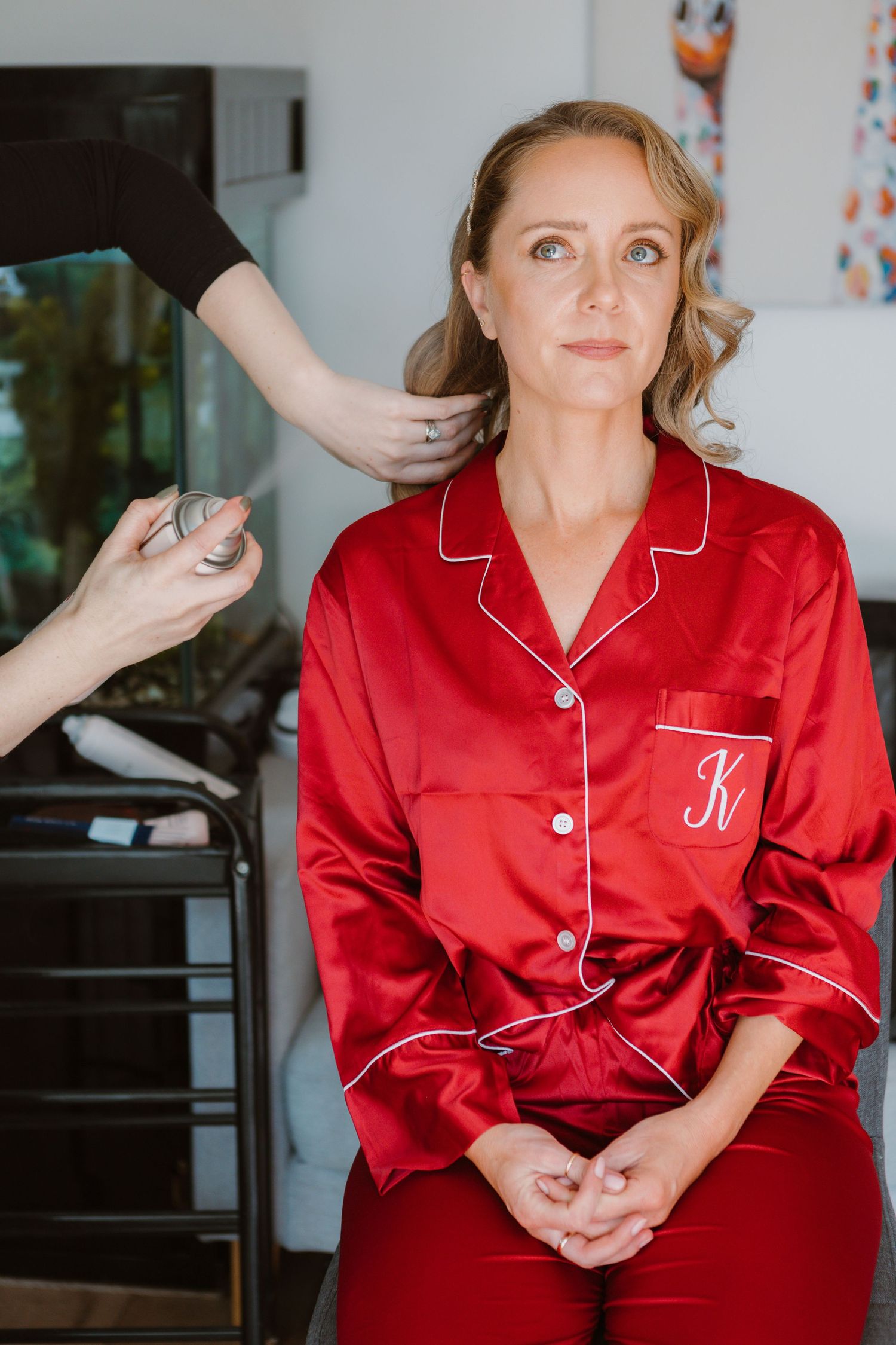 A person shown in a red satin pajama set with white piping details poses in a sequence of candid portraits.