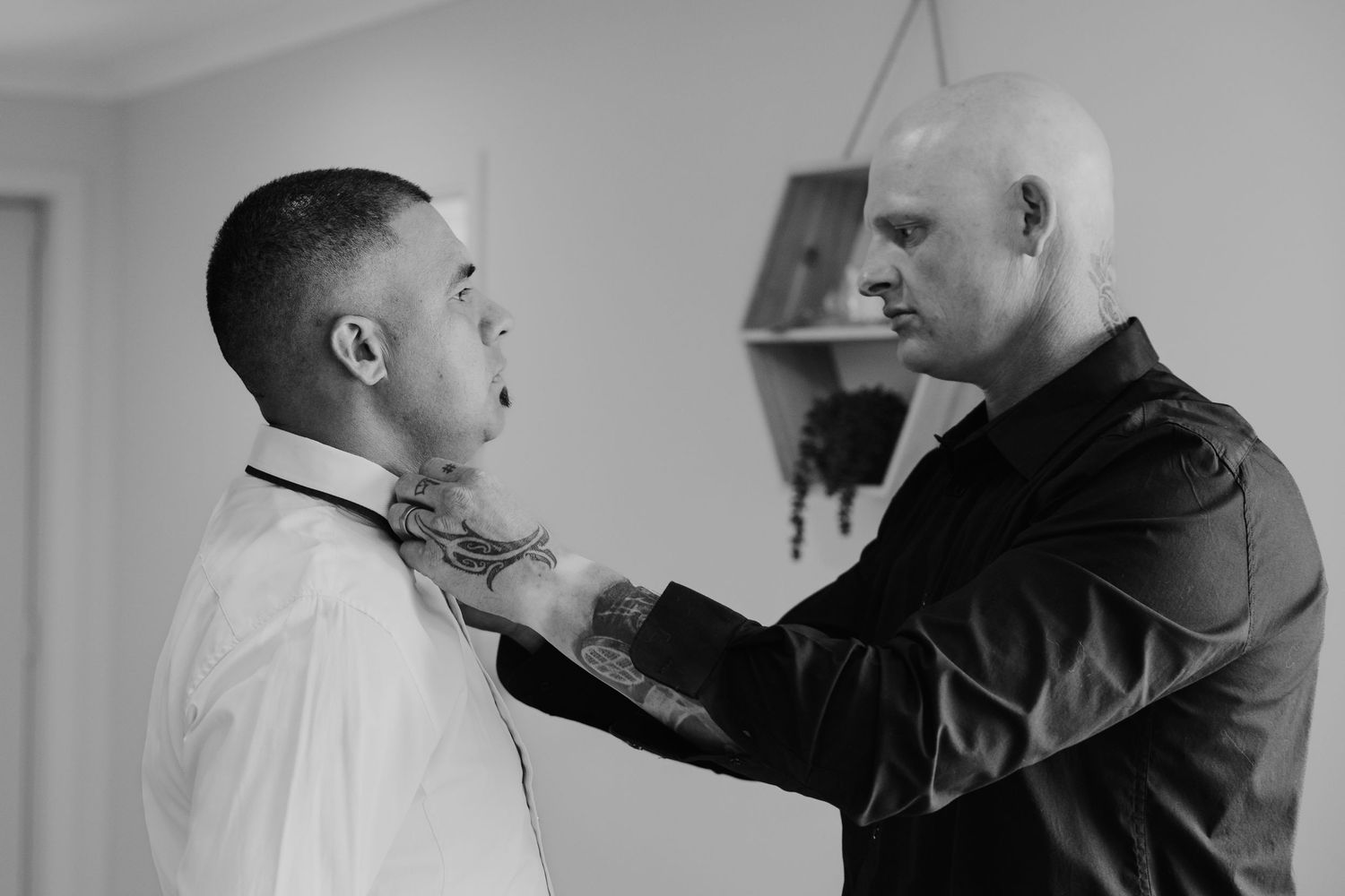 Two people in a tense confrontation, with one in a white shirt being grabbed by another in dark clothing.