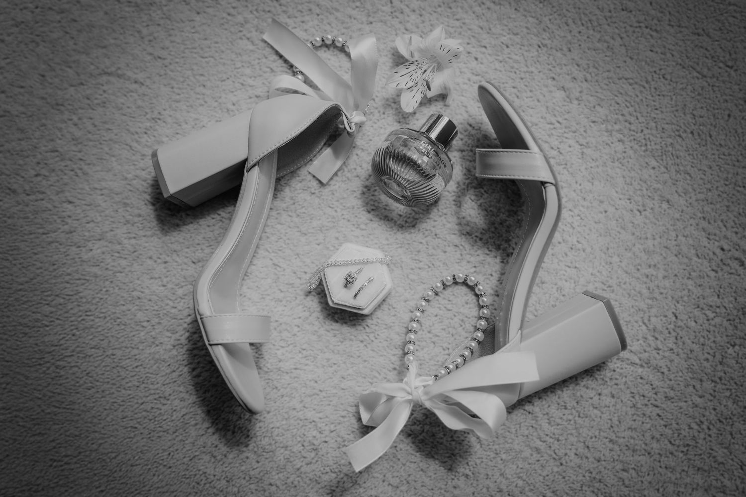 Black and white photo of small paper cranes scattered across a textured surface in dramatic lighting.