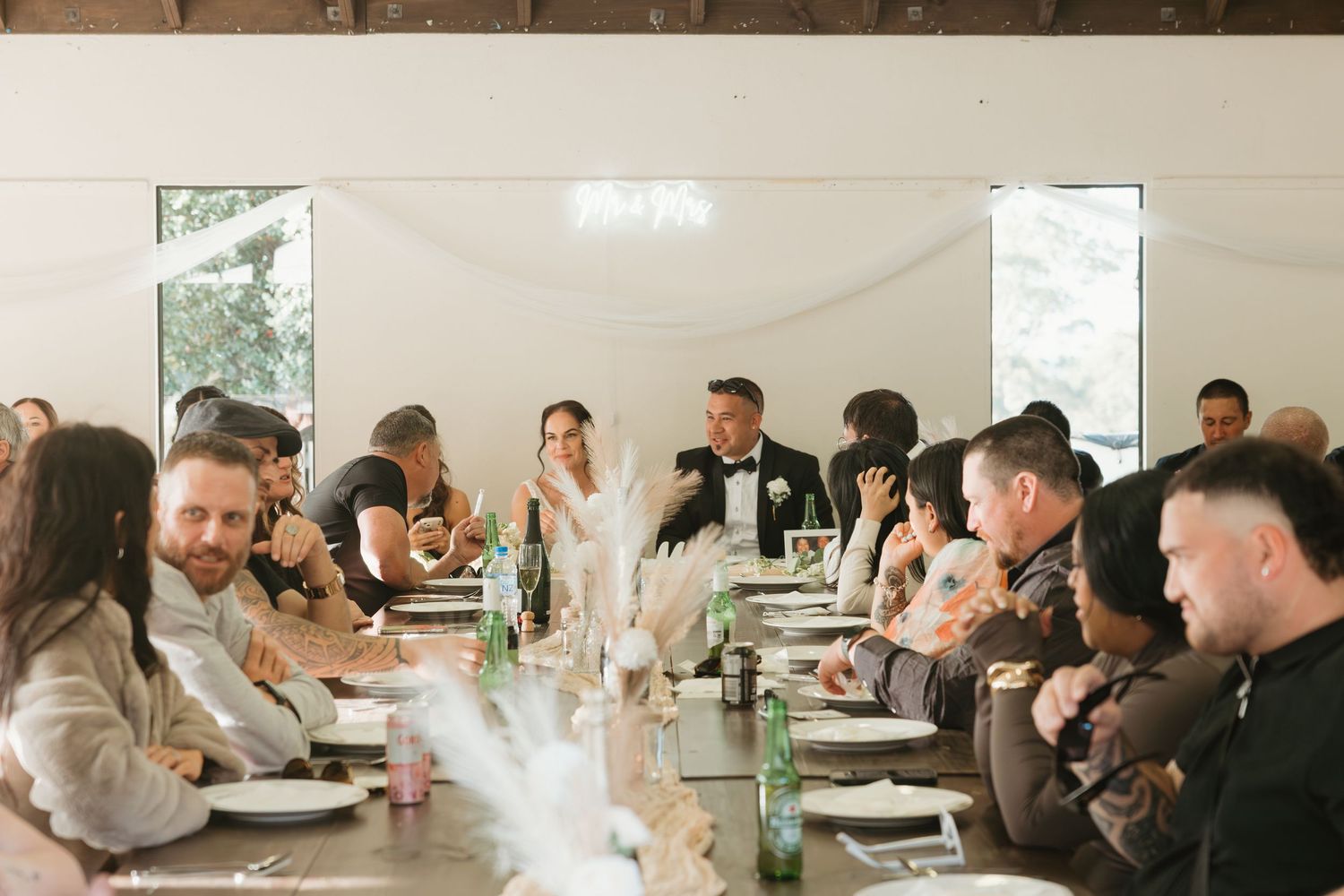 A group of people sit around tables during a business meeting or workshop in a bright modern space.