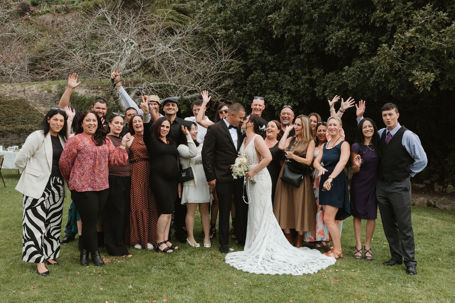 Wedding party poses playfully in a series of candid outdoor group shots on a grassy lawn.