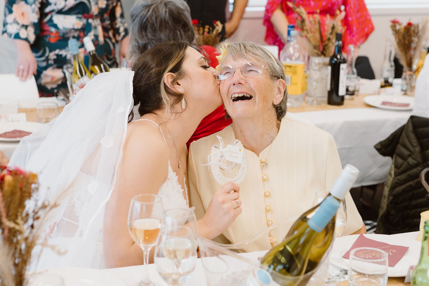 Wedding reception guests sharing laughs around tables decorated for celebration.