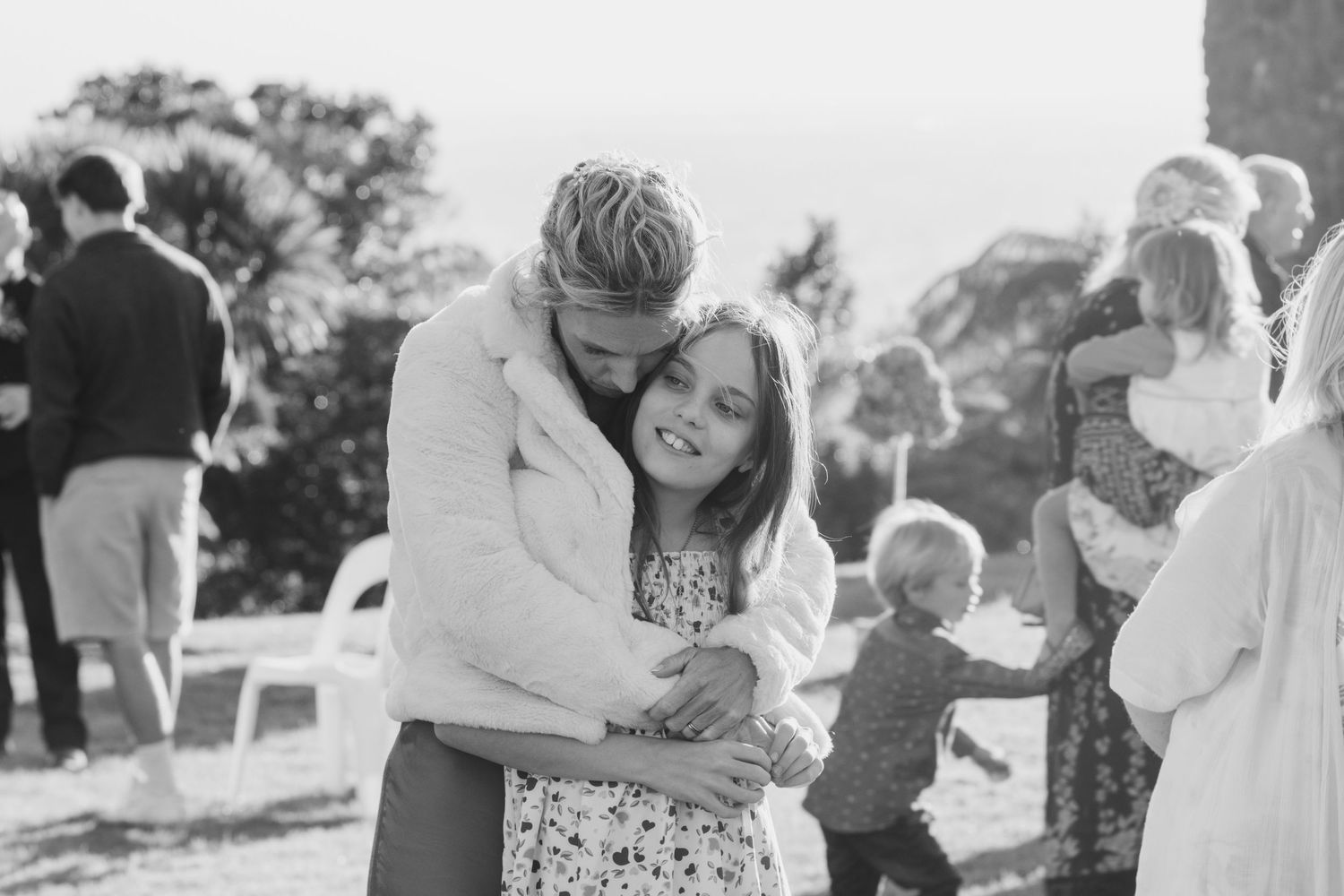 A collection of candid black and white photos showing joyful moments at an outdoor celebration.
