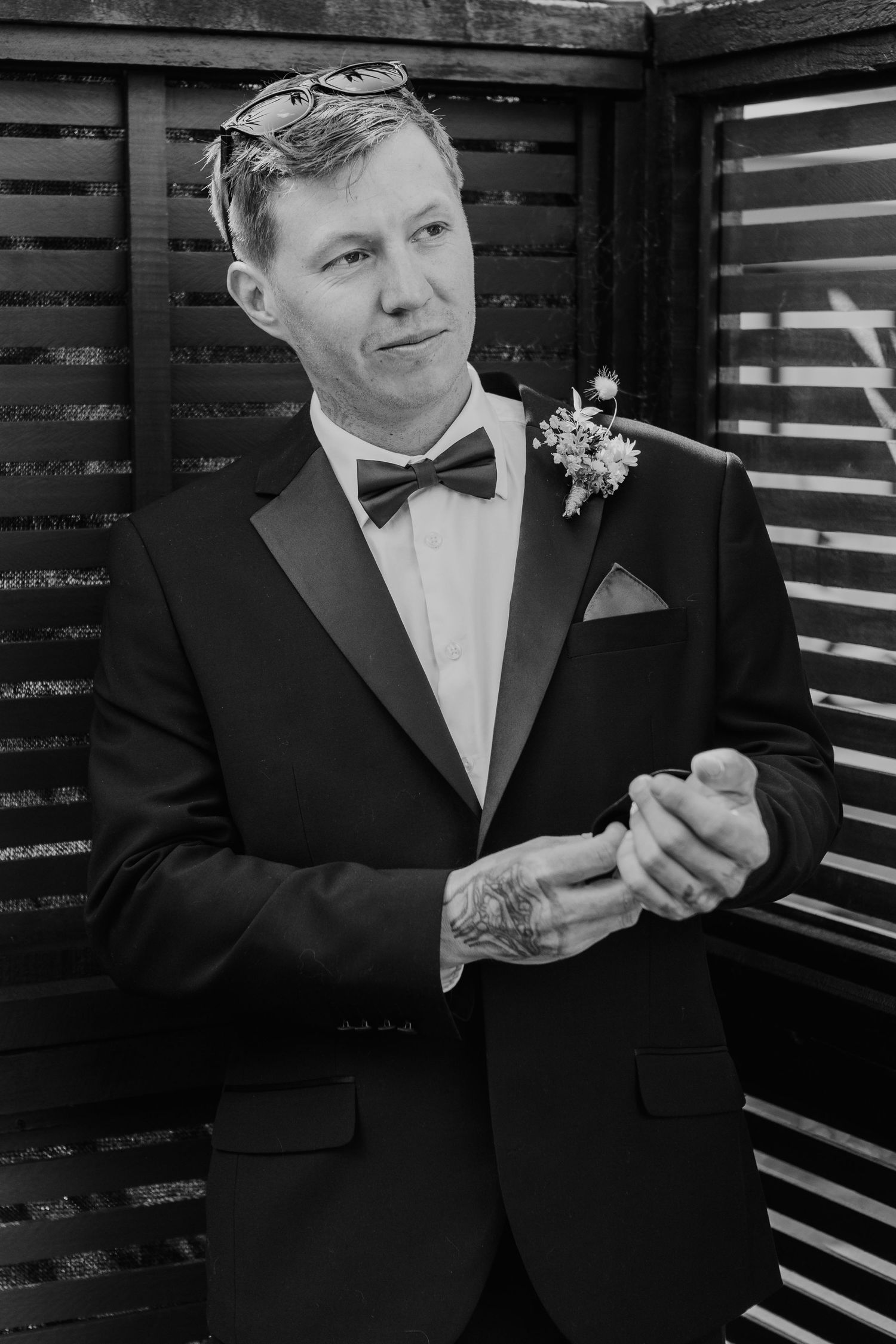 Black and white portrait series of someone in a formal tuxedo showing laughter and joy on their wedding day.