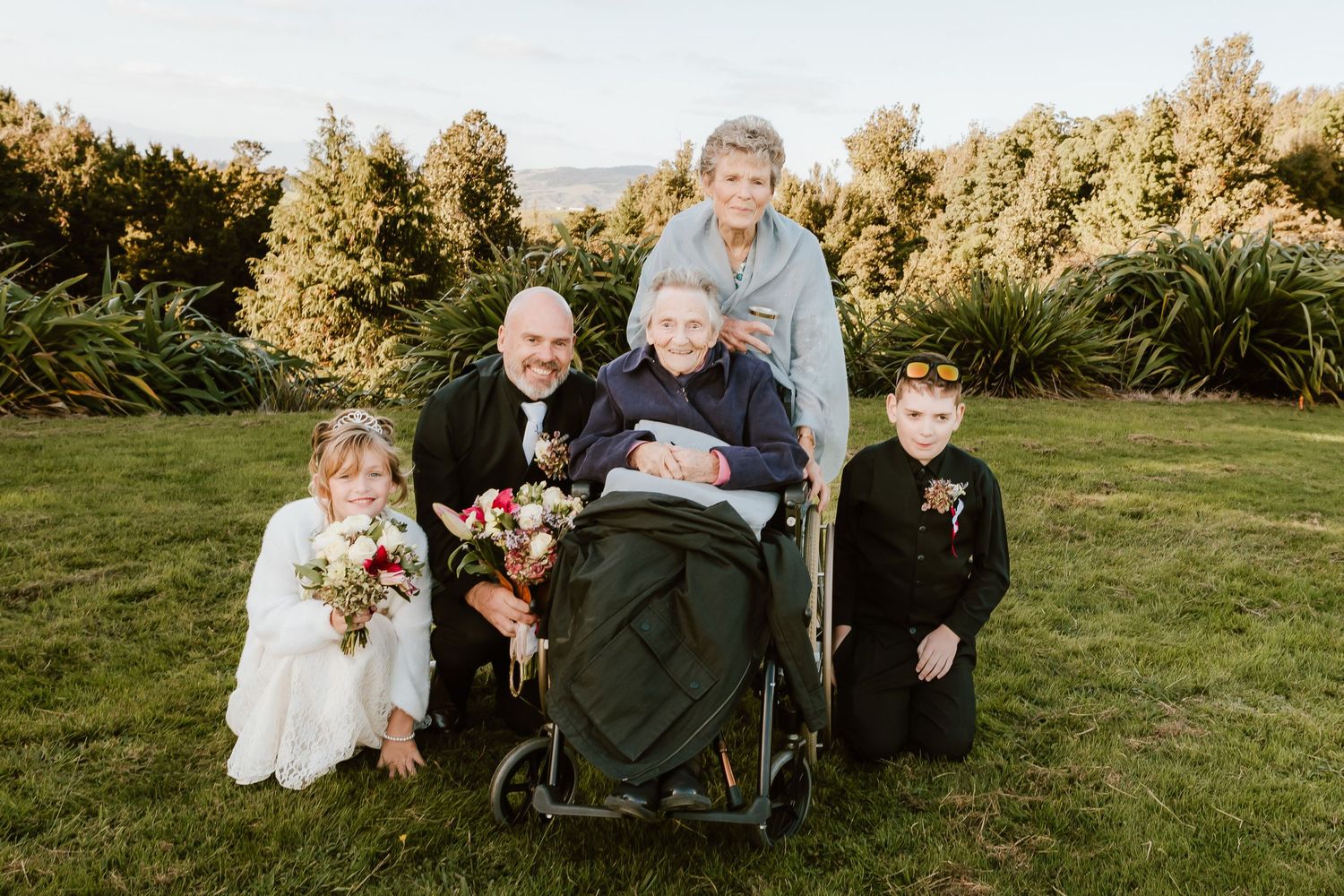 A rustic outdoor autumn celebration features a gathered group in coordinating earth tones against a natural backdrop.