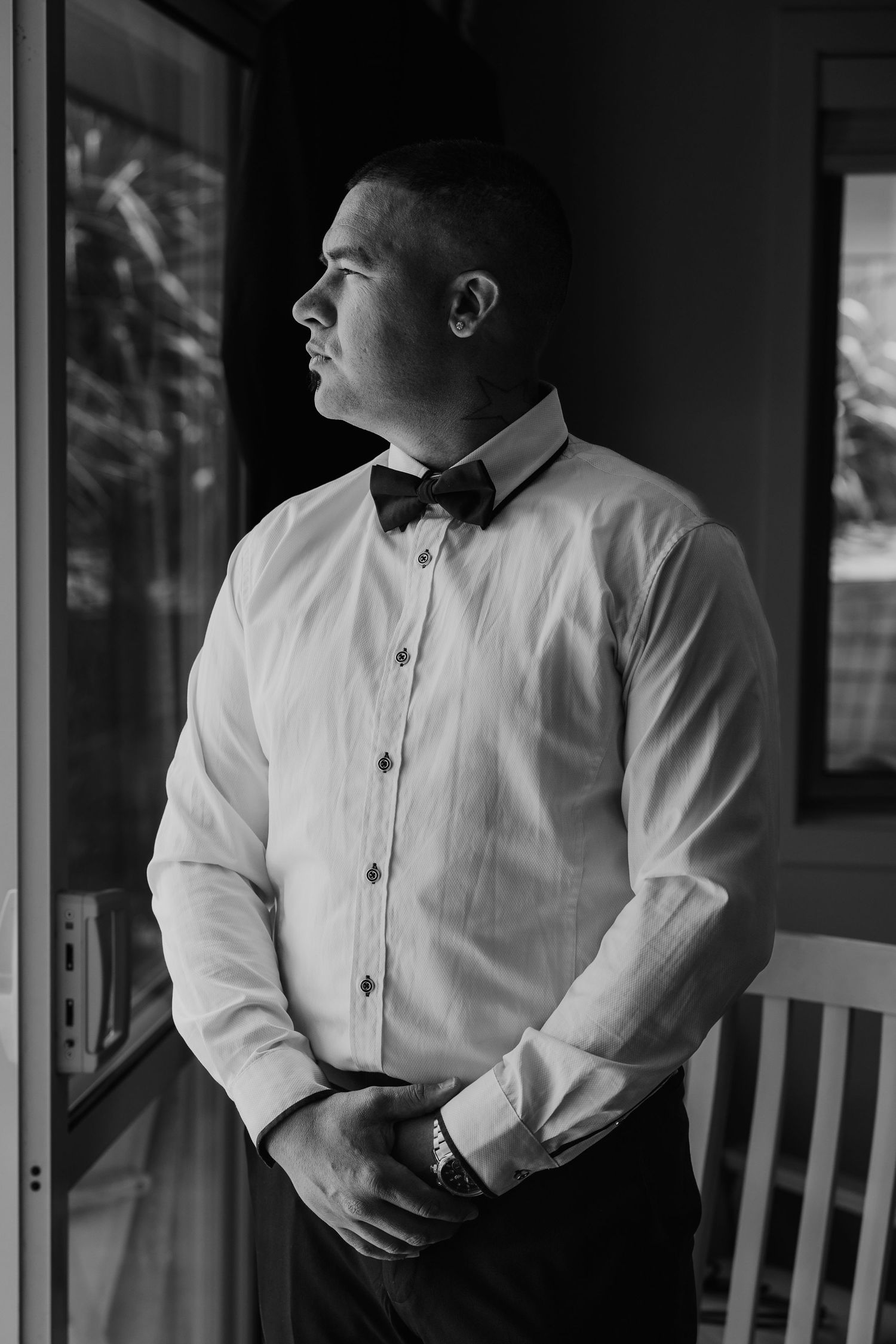 Black and white portrait series showing a person in a white button-down shirt looking pensively out a window.