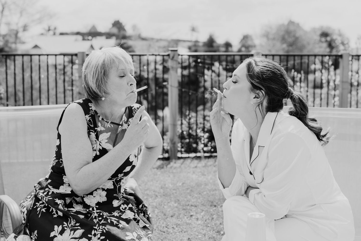 A candid black and white moment shared between two people enjoying conversation in an outdoor patio setting.