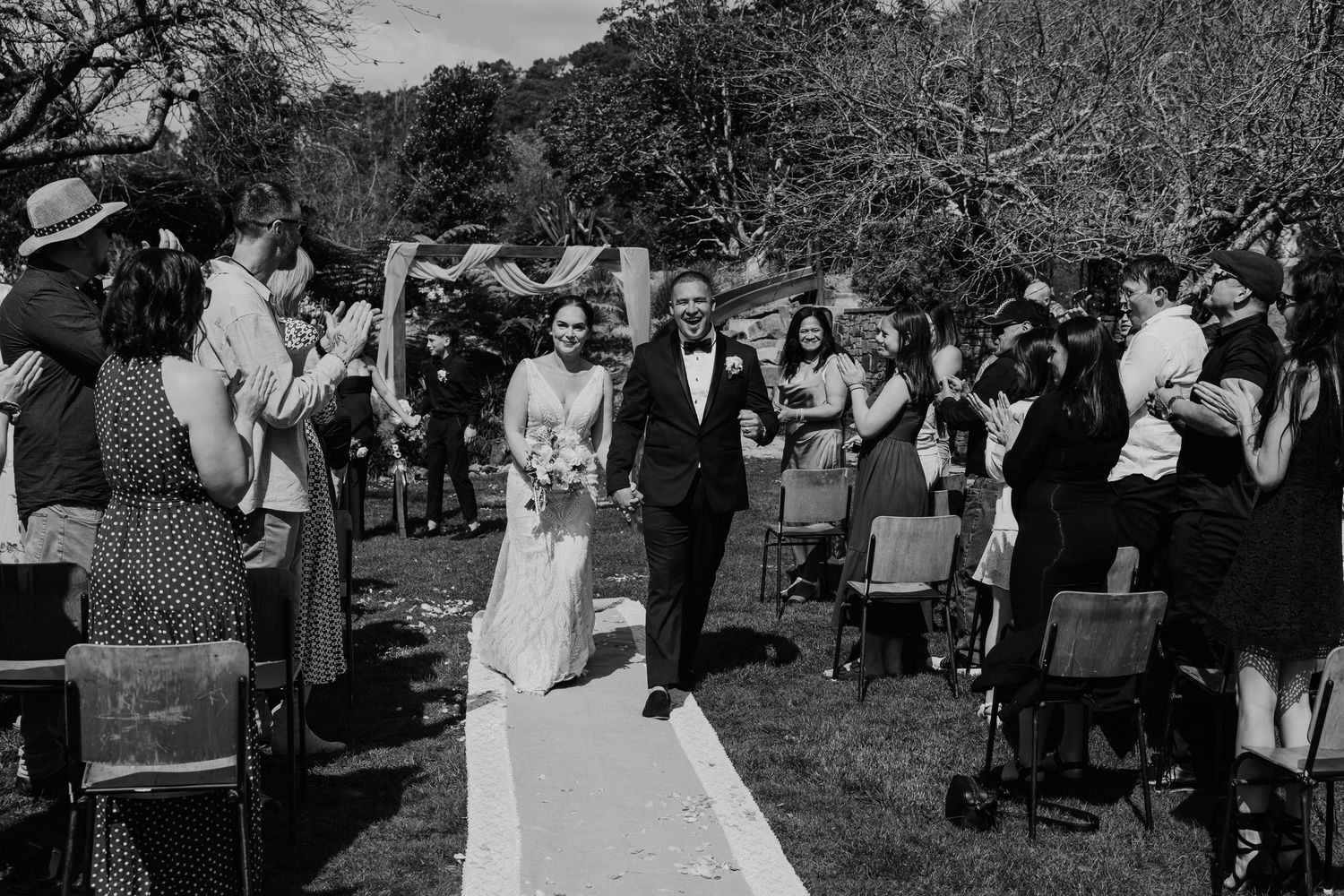 Black and white photo collage showing multiple wedding celebration scenes outdoors with guests and decorations.