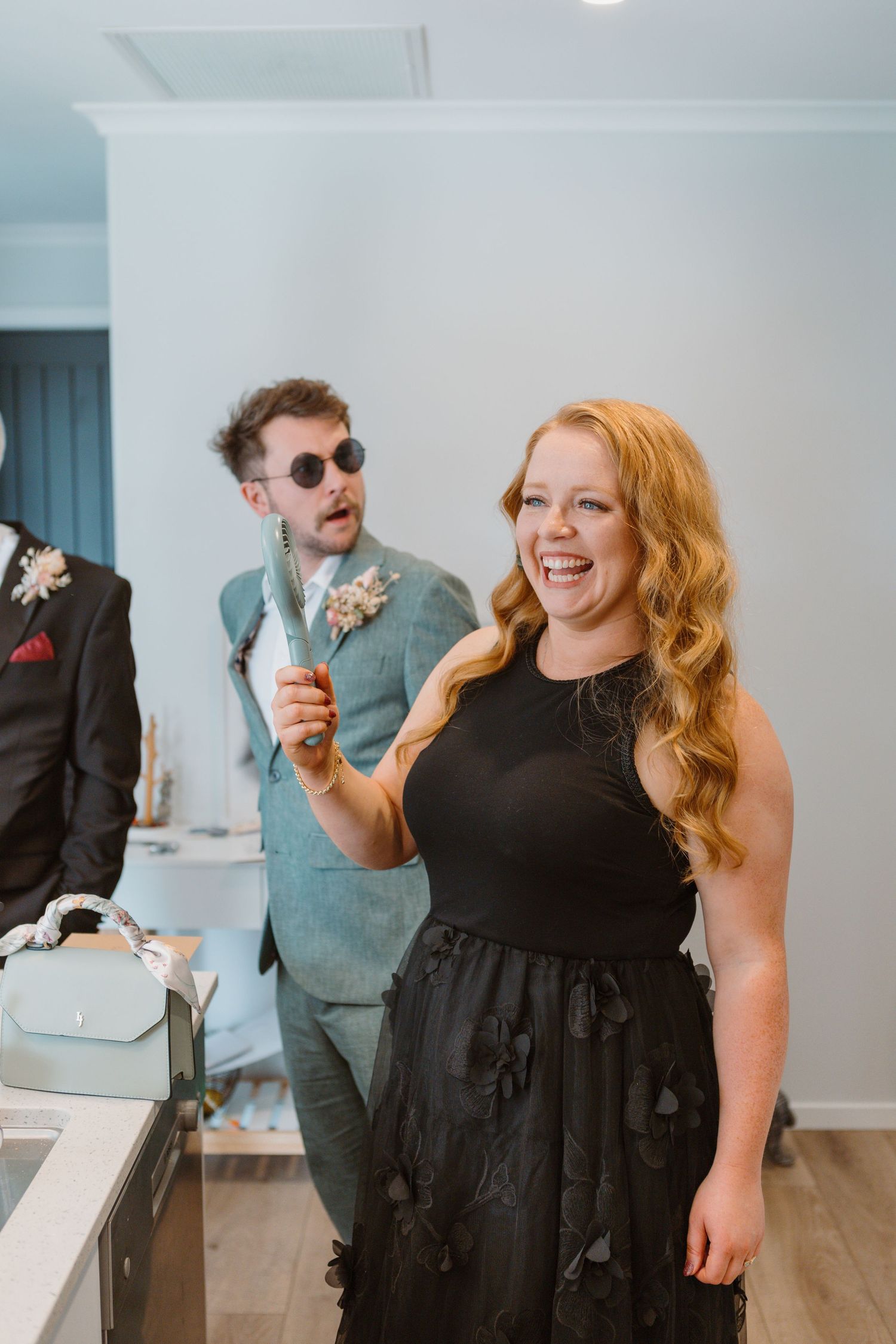 Wedding partygoers dressed in black and blue attire share a fun moment with ice cream at an indoor celebration.