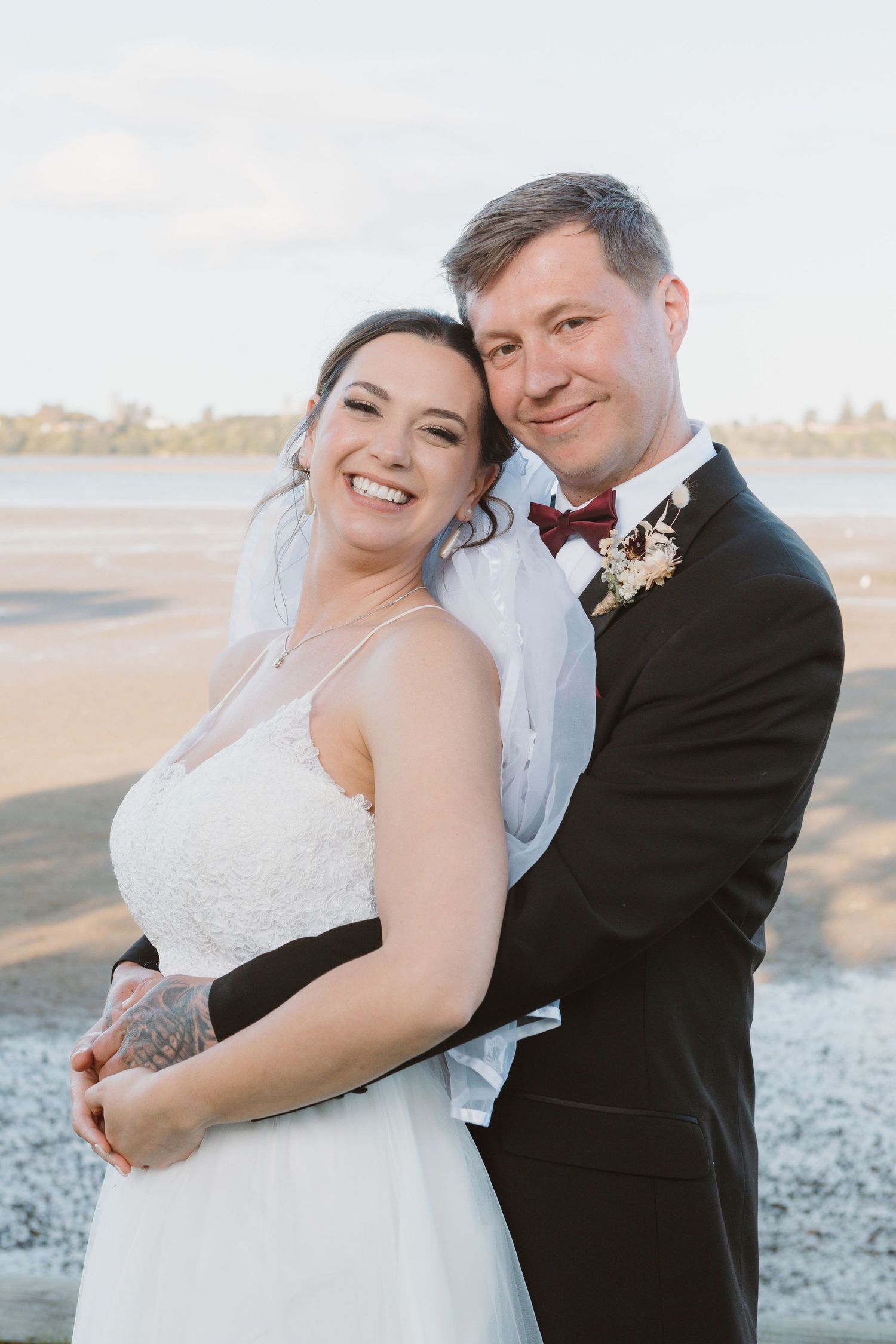 Wedding portraits on beach with classic black and white formal attire.