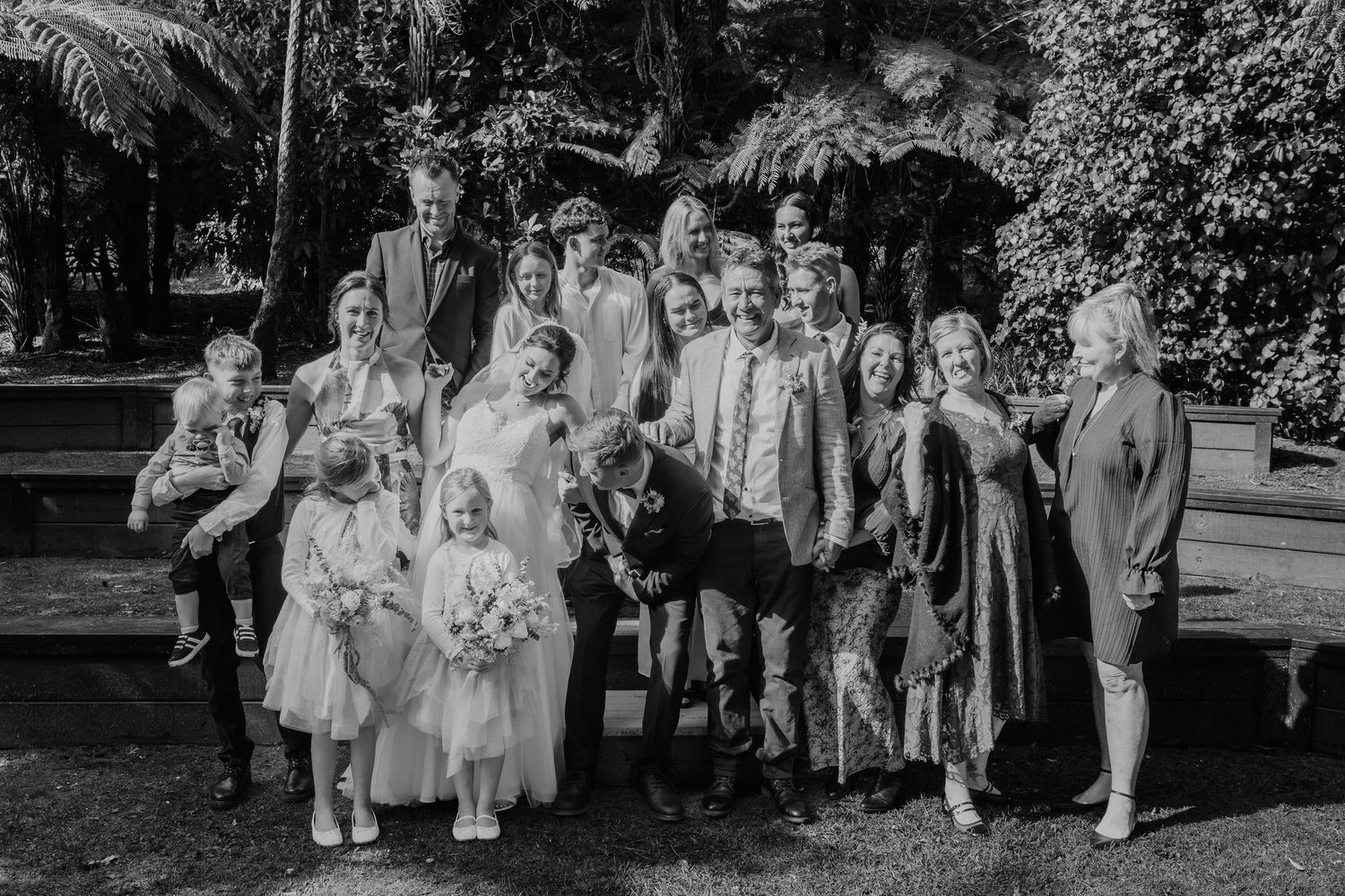 Intimate family wedding portrait with children and adults arranged on outdoor garden steps.
