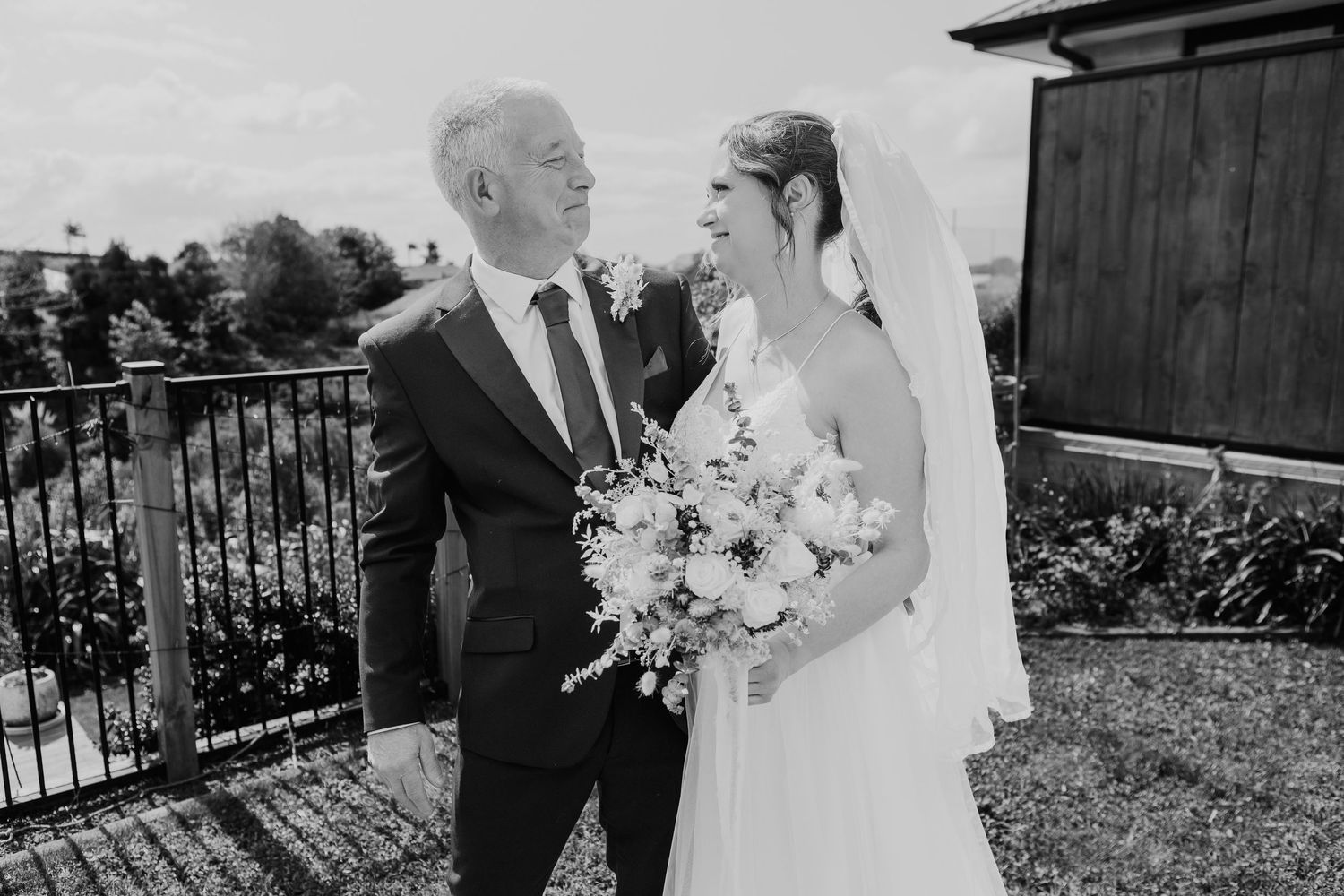 Wedding couple in black and white share an intimate moment outdoors during their celebration.