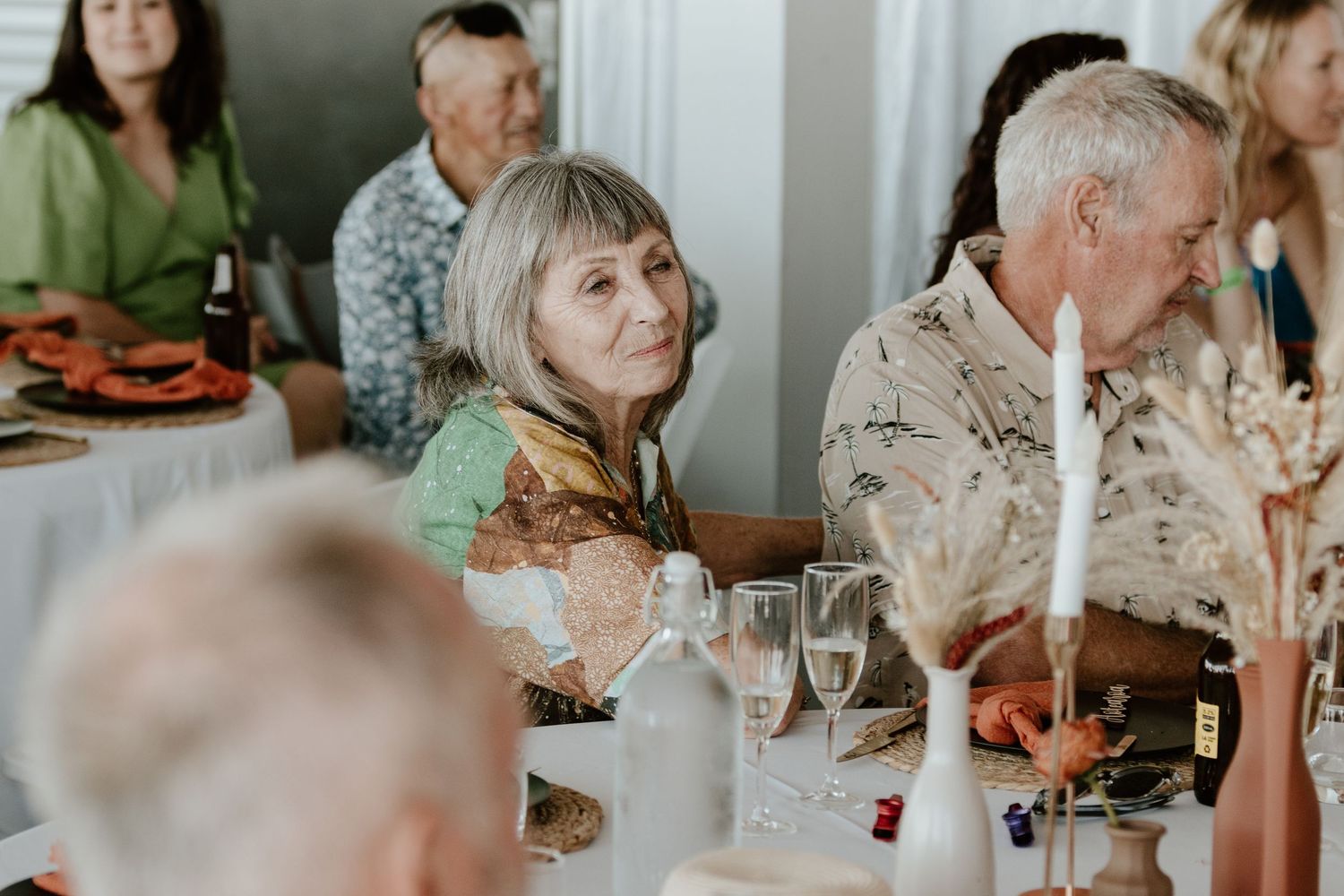 Wedding reception guests seated at tables enjoying conversation and drinks. Papamoa Surf Lifesaving Club Wedding