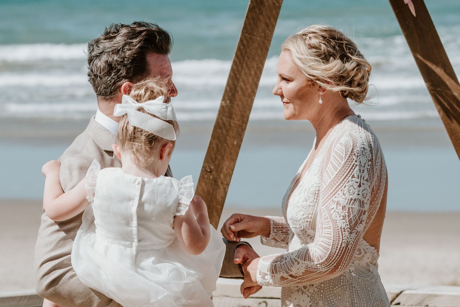 An intimate moment shared during a seaside wedding ceremony. Papamoa Surf Lifesaving Club Wedding