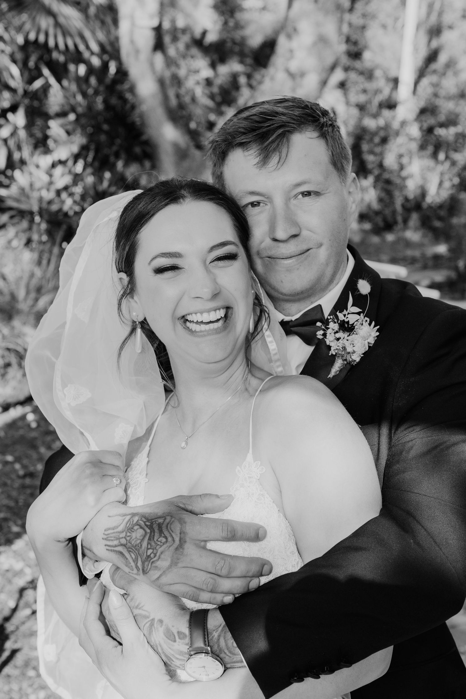Black and white wedding photos show joyful moments between newlyweds during outdoor photo session.