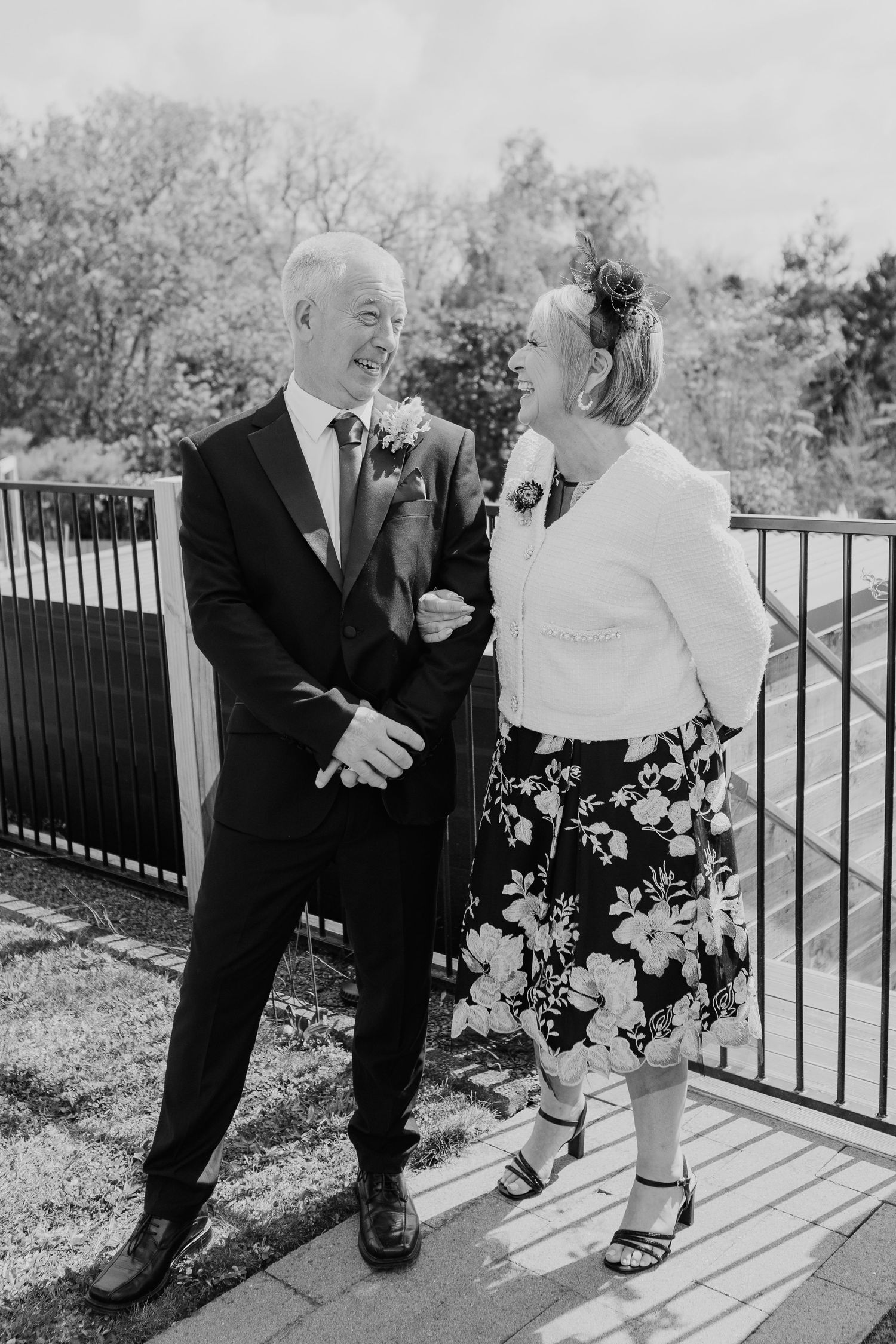 A black and white collage showing a couple sharing laughter and playful moments near an outdoor railing.