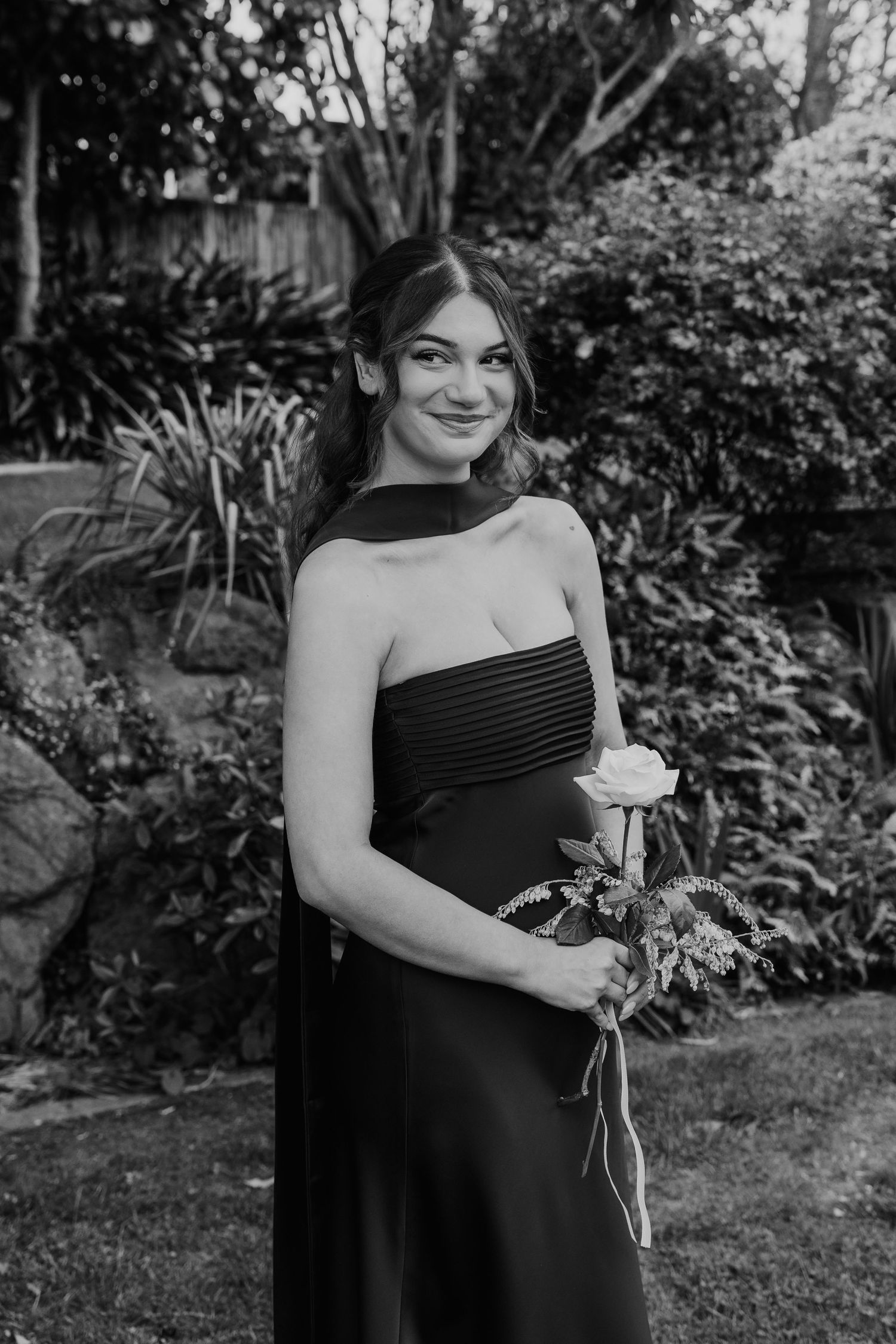 Black and white photo series of a person in a dark dress holding a rose in a garden setting.