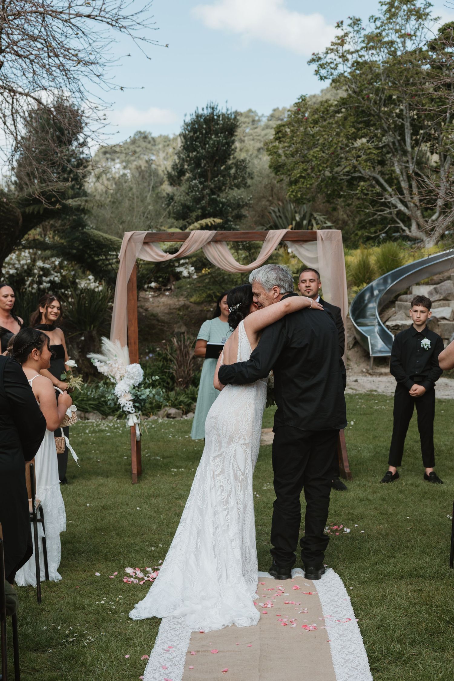 A sequence of four photos showing a couple dancing and twirling during their outdoor wedding celebration.