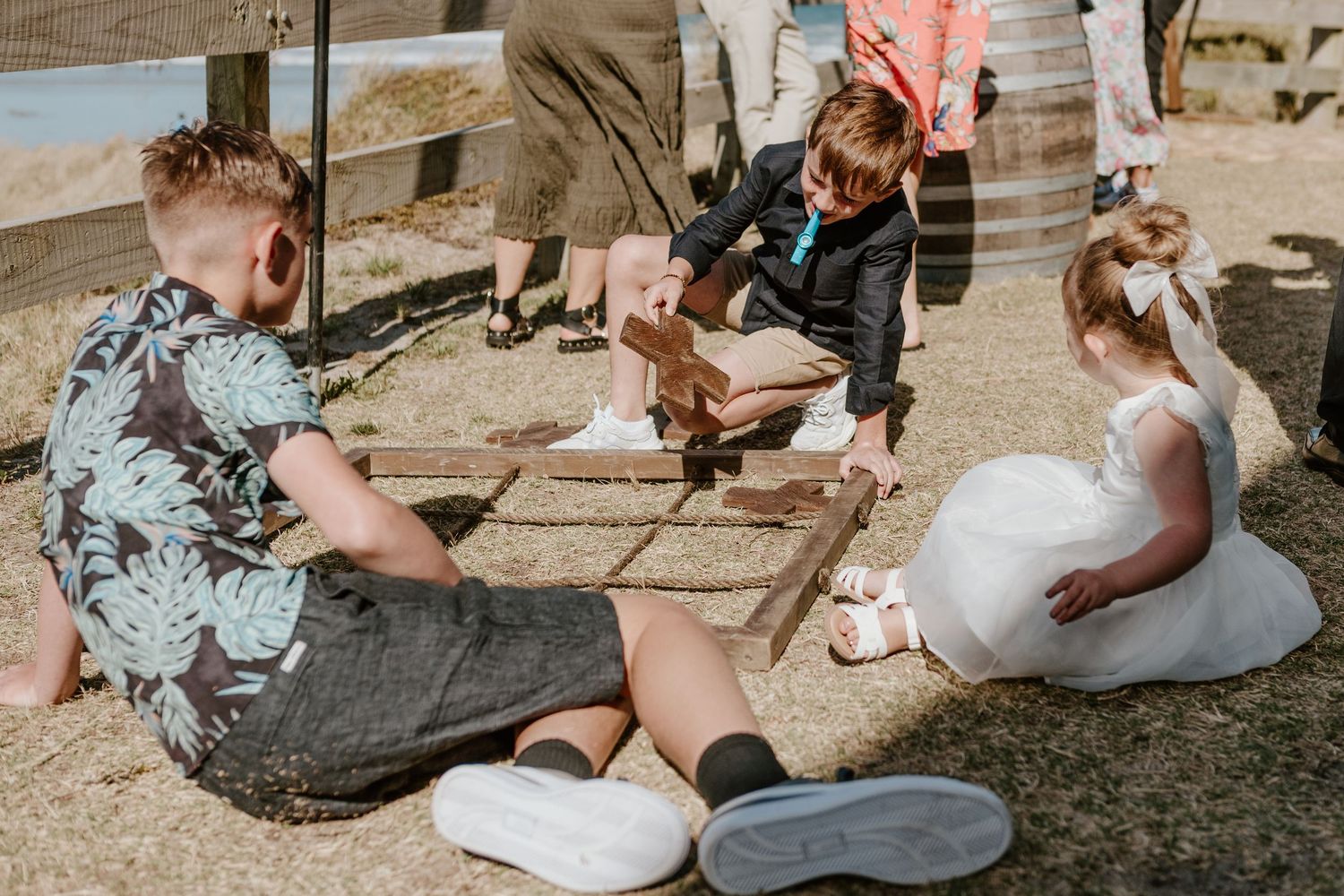 Wedding guests gather on wooden deck during outdoor celebration. Outdoor  wedding games. Papamoa Surf Lifesaving Club Wedding