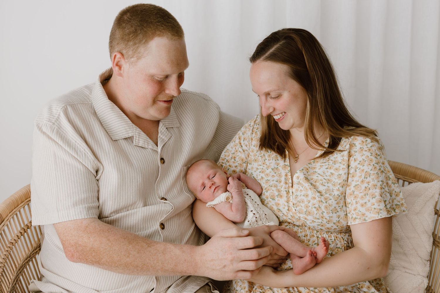 A series of tender family moments with a newborn baby in a neutral-toned bedroom setting.