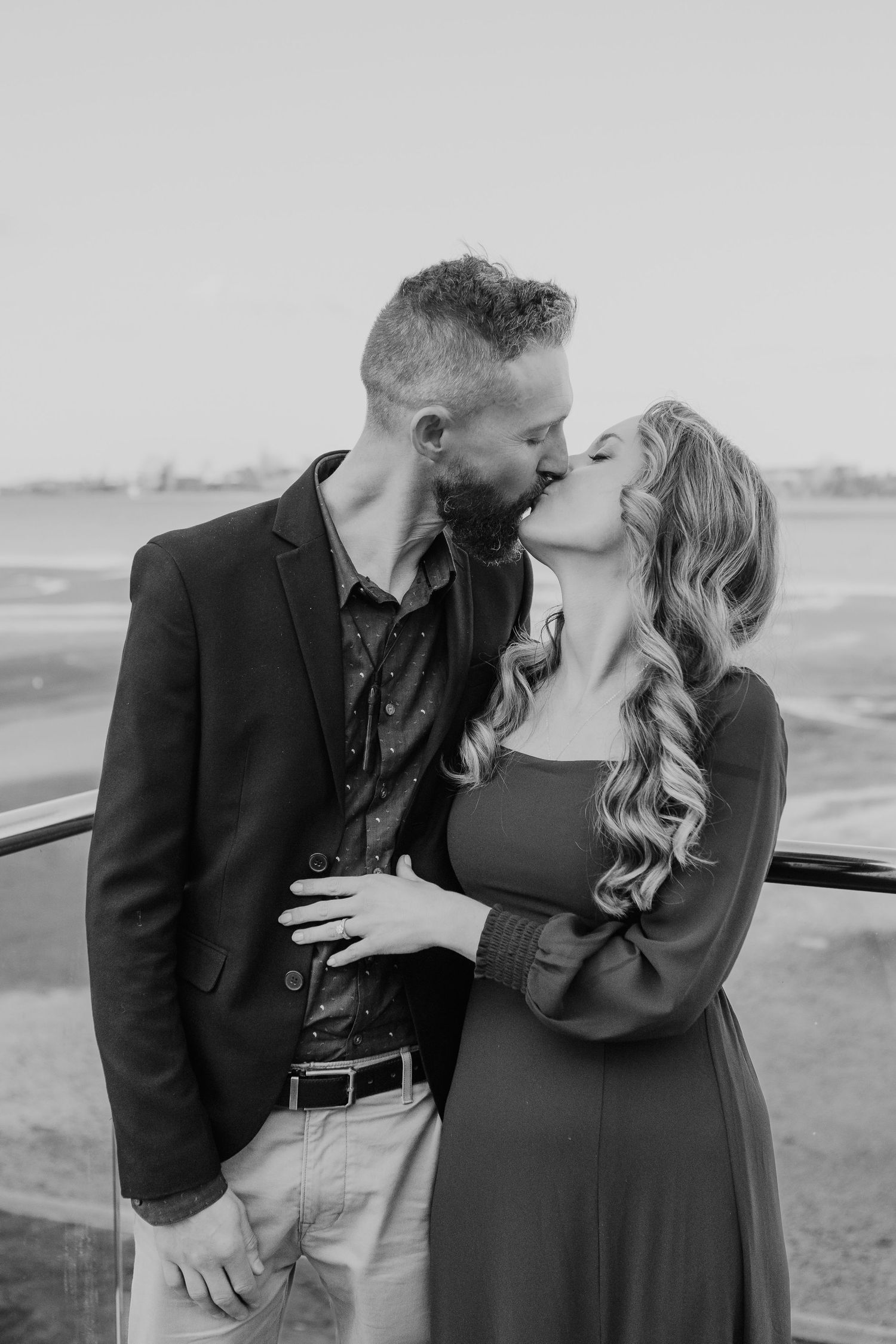 Romantic couple embraces during black and white outdoor photo session.