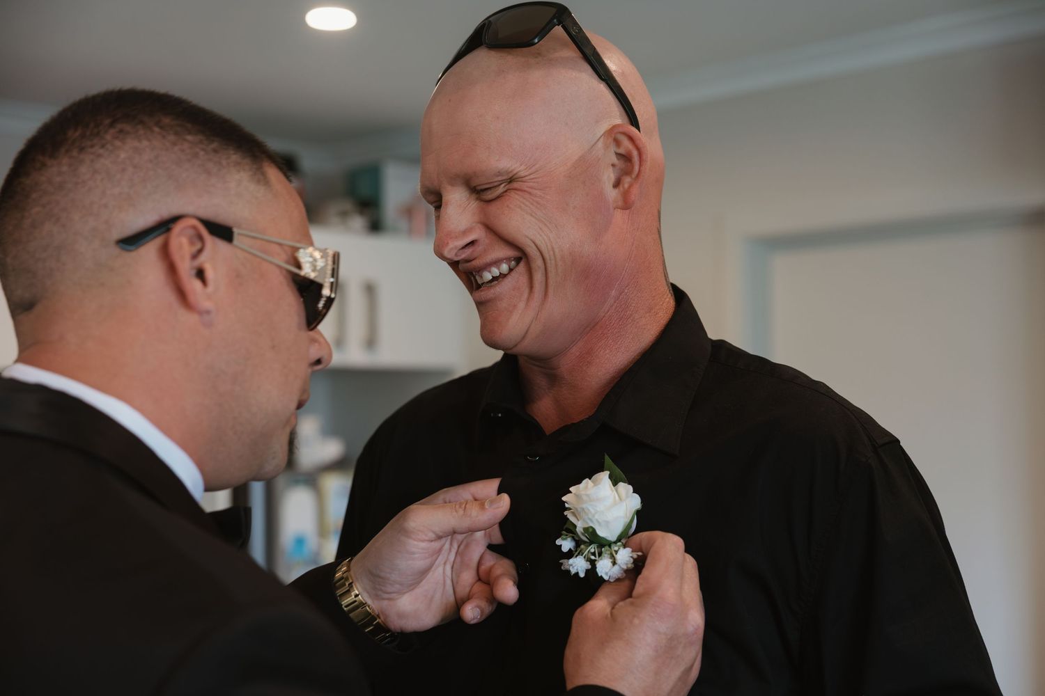 A groom and officiant share a lighthearted moment during a wedding ceremony.
