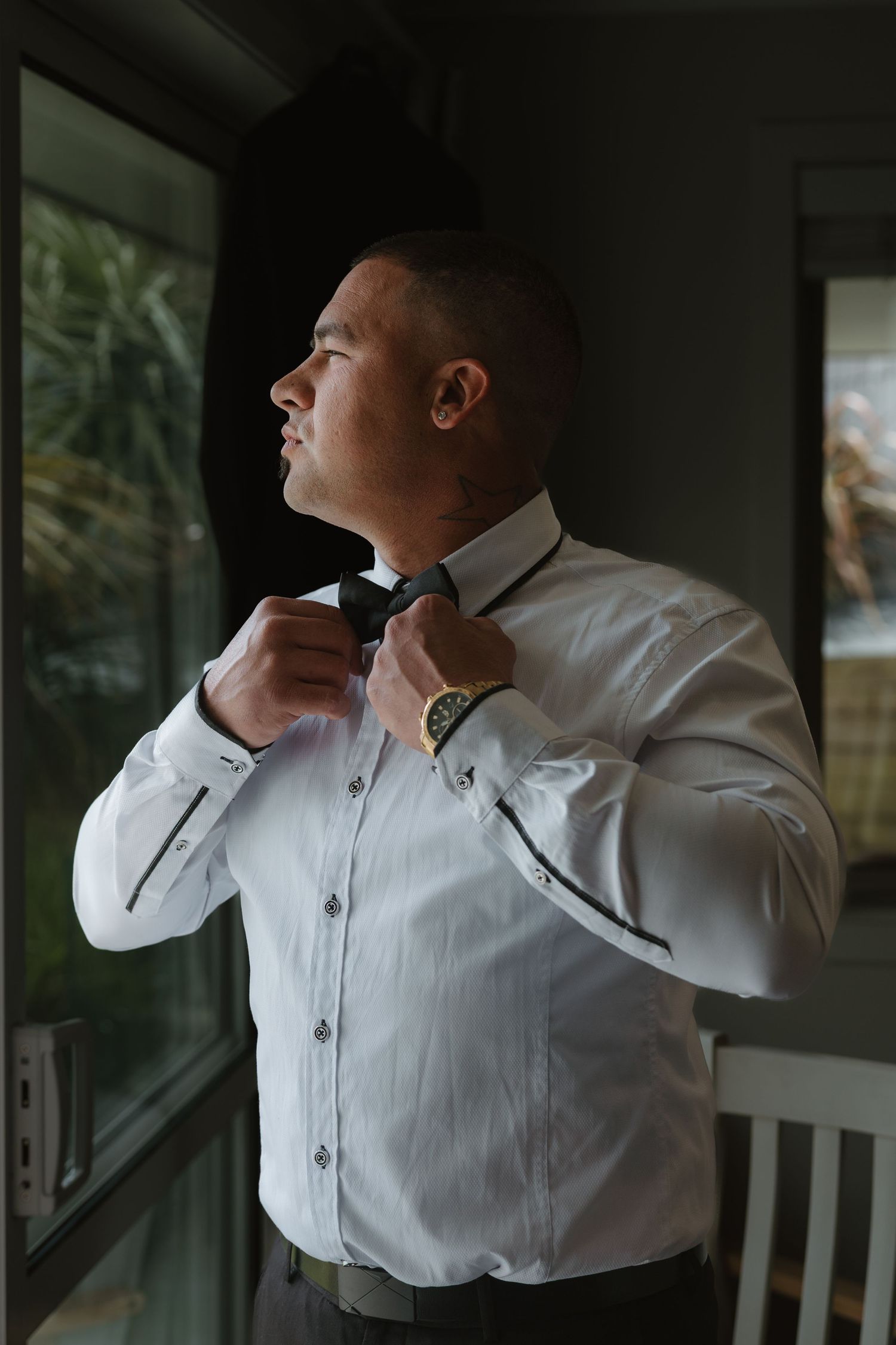 Person in white dress shirt adjusts their collar while looking away in a series of profile shots.