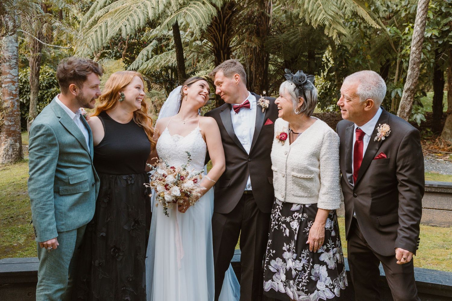 Intimate candid moment shared between wedding party members during outdoor photo session.