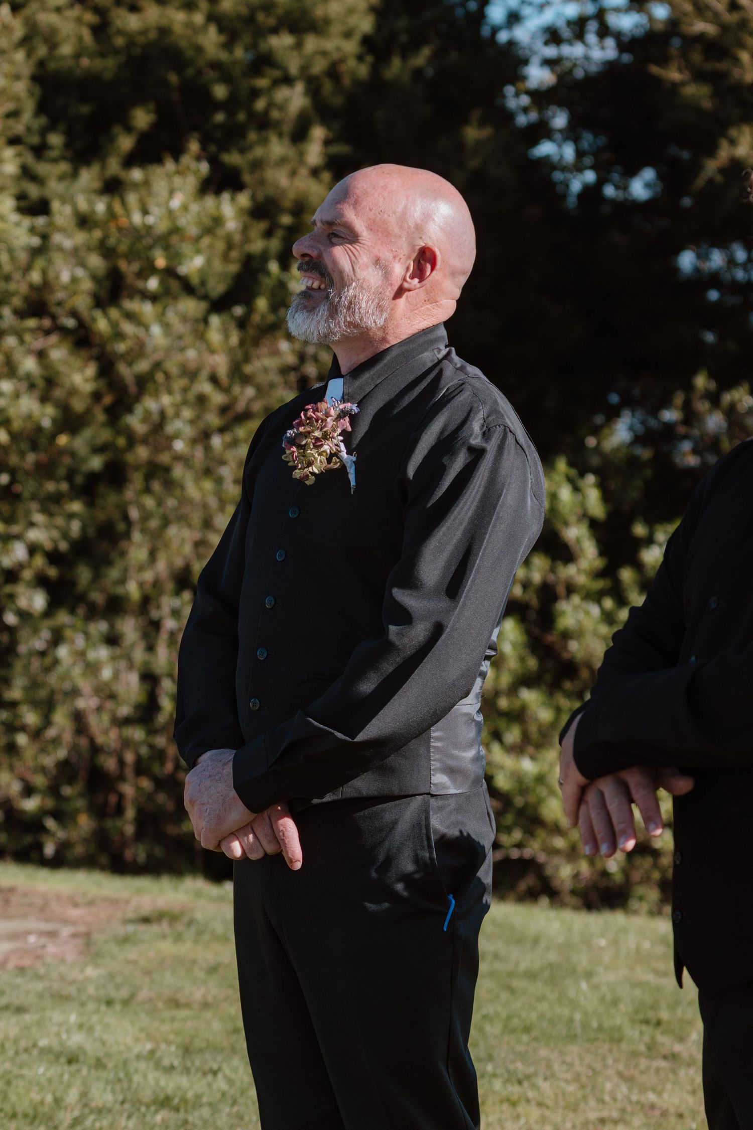 Five sequential photos show someone in a black suit wiping tears from their eyes in an outdoor setting.