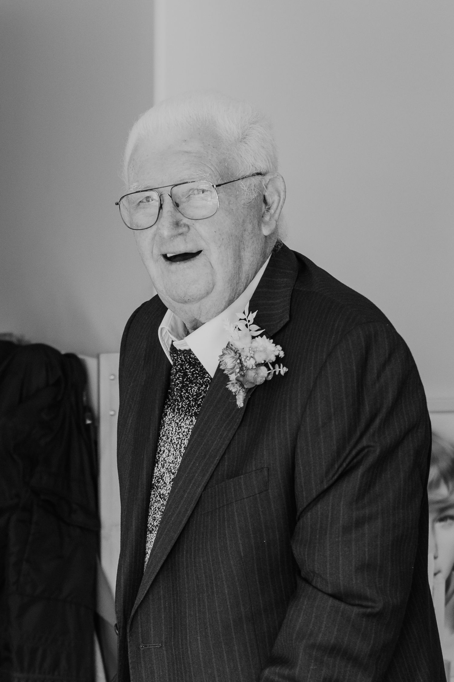 Black and white portrait sequence showing someone in formal attire with glasses smiling.