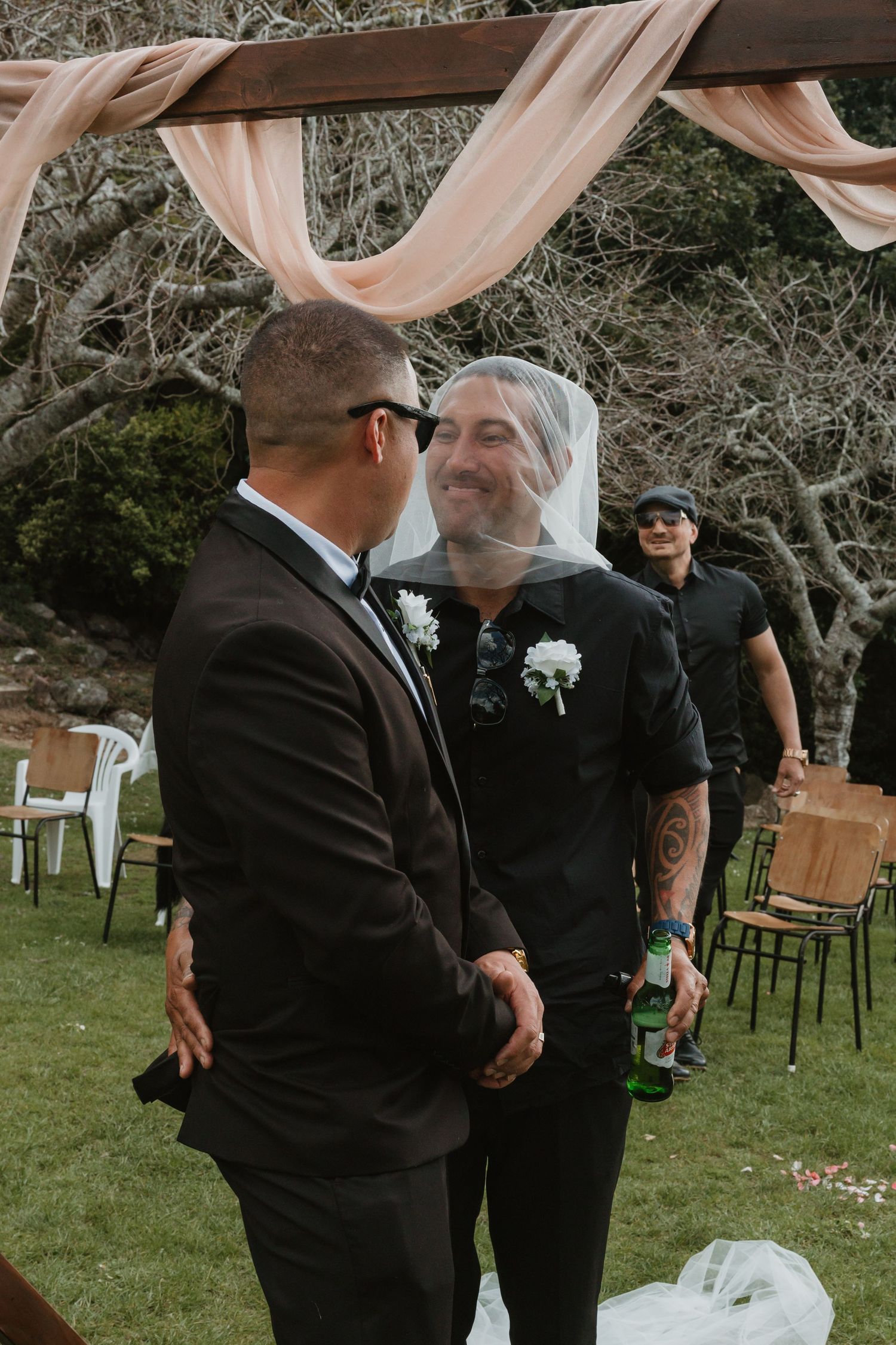 A series of wedding ceremony moments outdoors with guests under blush pink fabric draping and natural tree canopy.