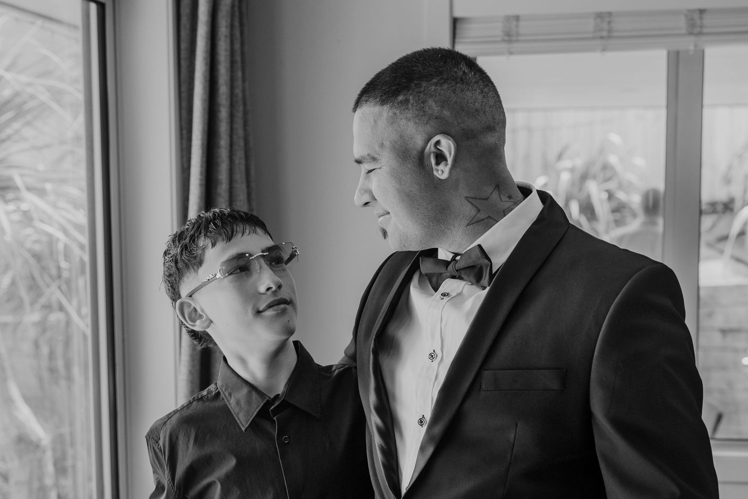 A group of people in formal attire gather together and laugh during a social event.