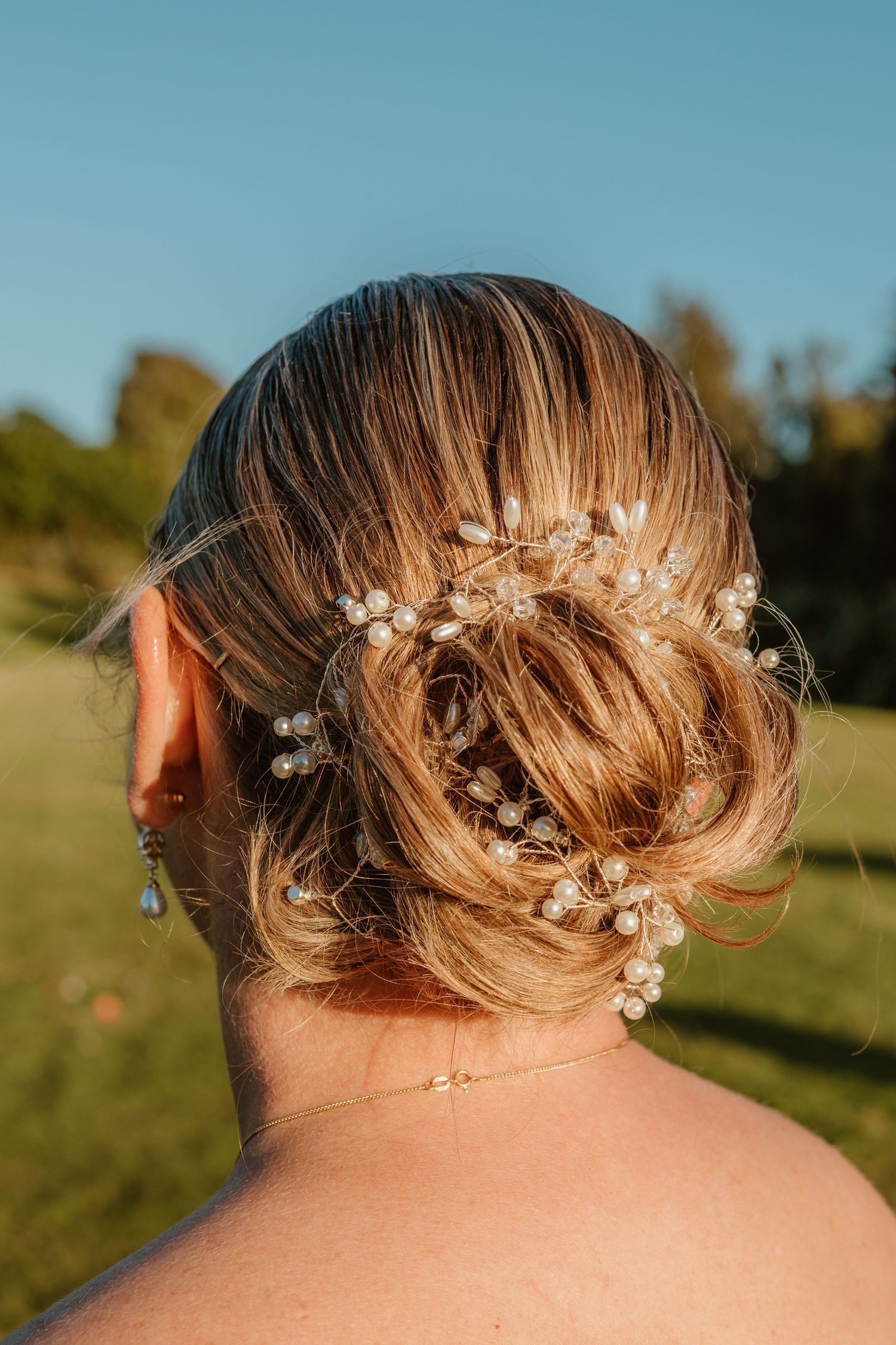Delicate floral hair accessories adorn an elegant updo hairstyle captured from various angles in golden sunlight.