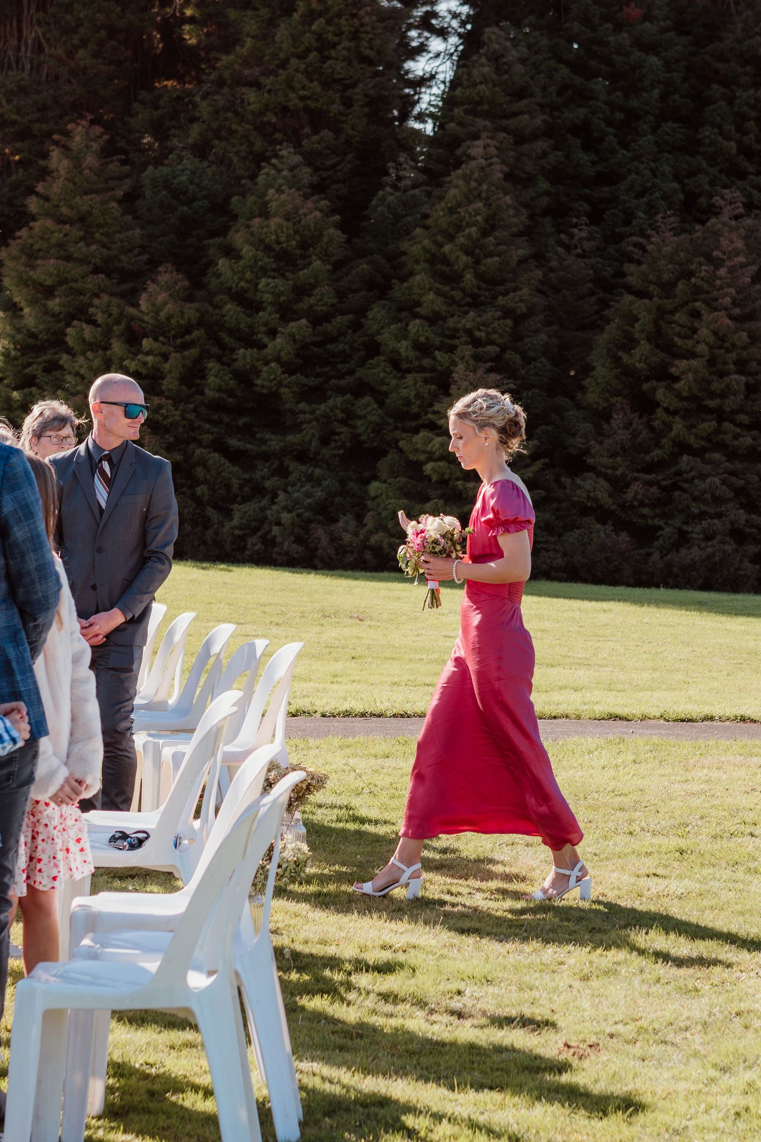 A series of candid moments at an outdoor event with people walking between white chairs on a sunny grassy lawn.