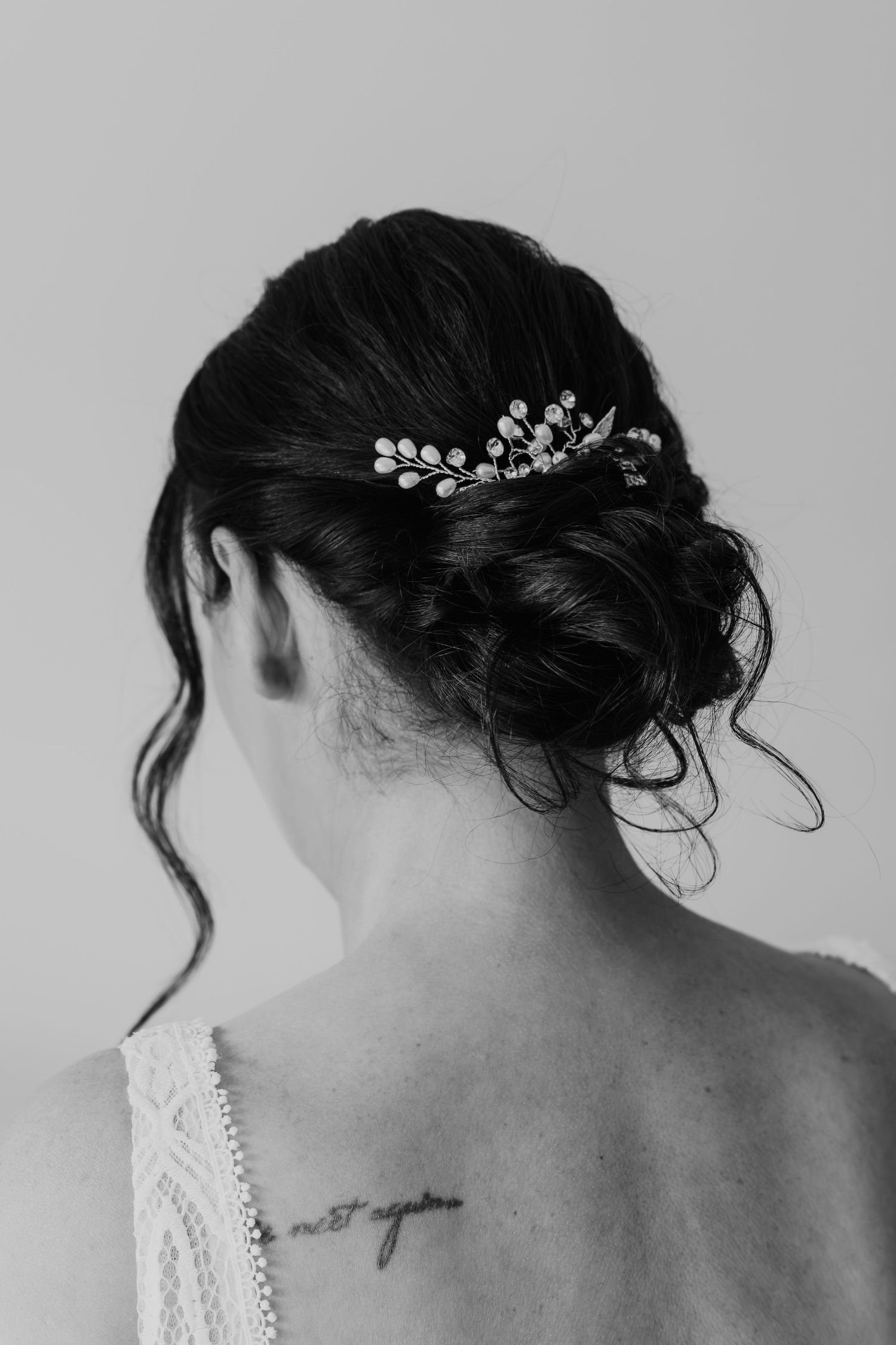 A series of black and white photos showing an elegant updo hairstyle adorned with a delicate crystal hair accessory.