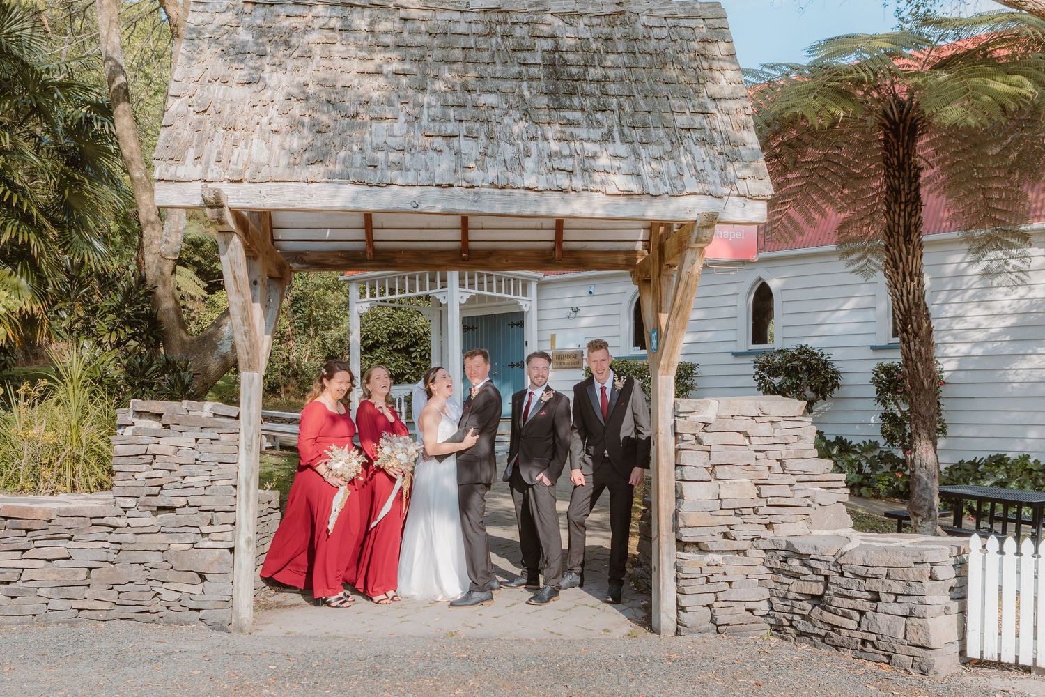 Stone wall backdrop serves as a rustic setting for an outdoor photo session at a historic venue.