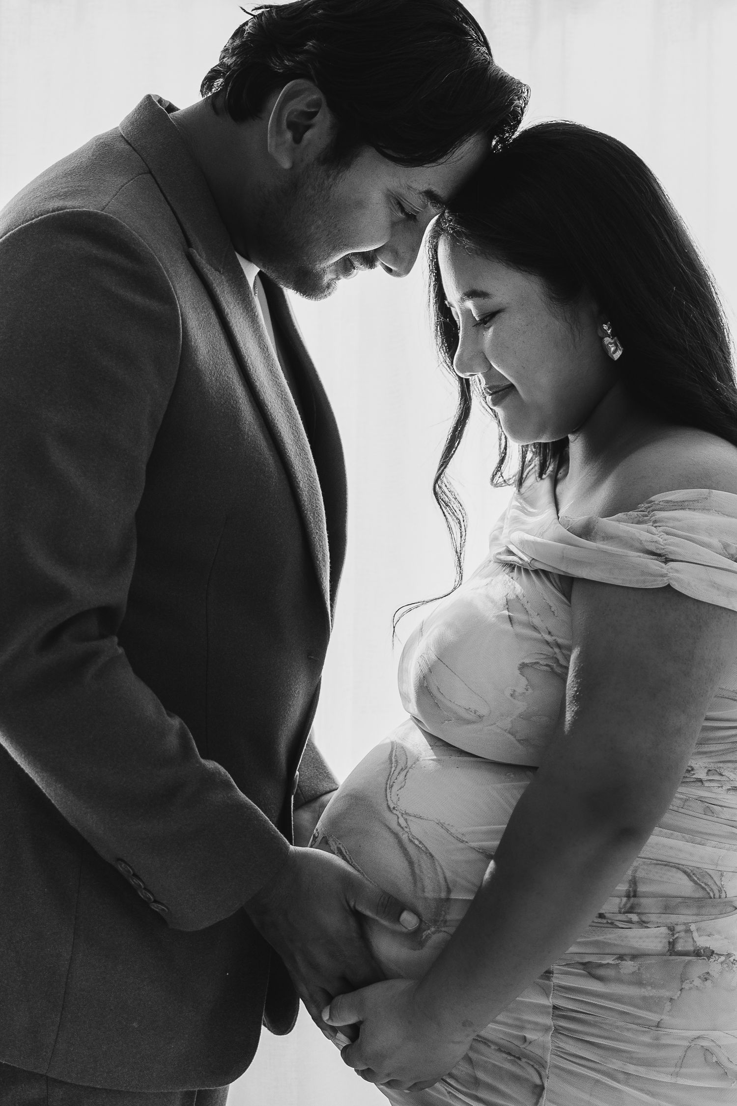 Intimate black and white maternity photo sequence showing close moments between a couple expecting a baby.
