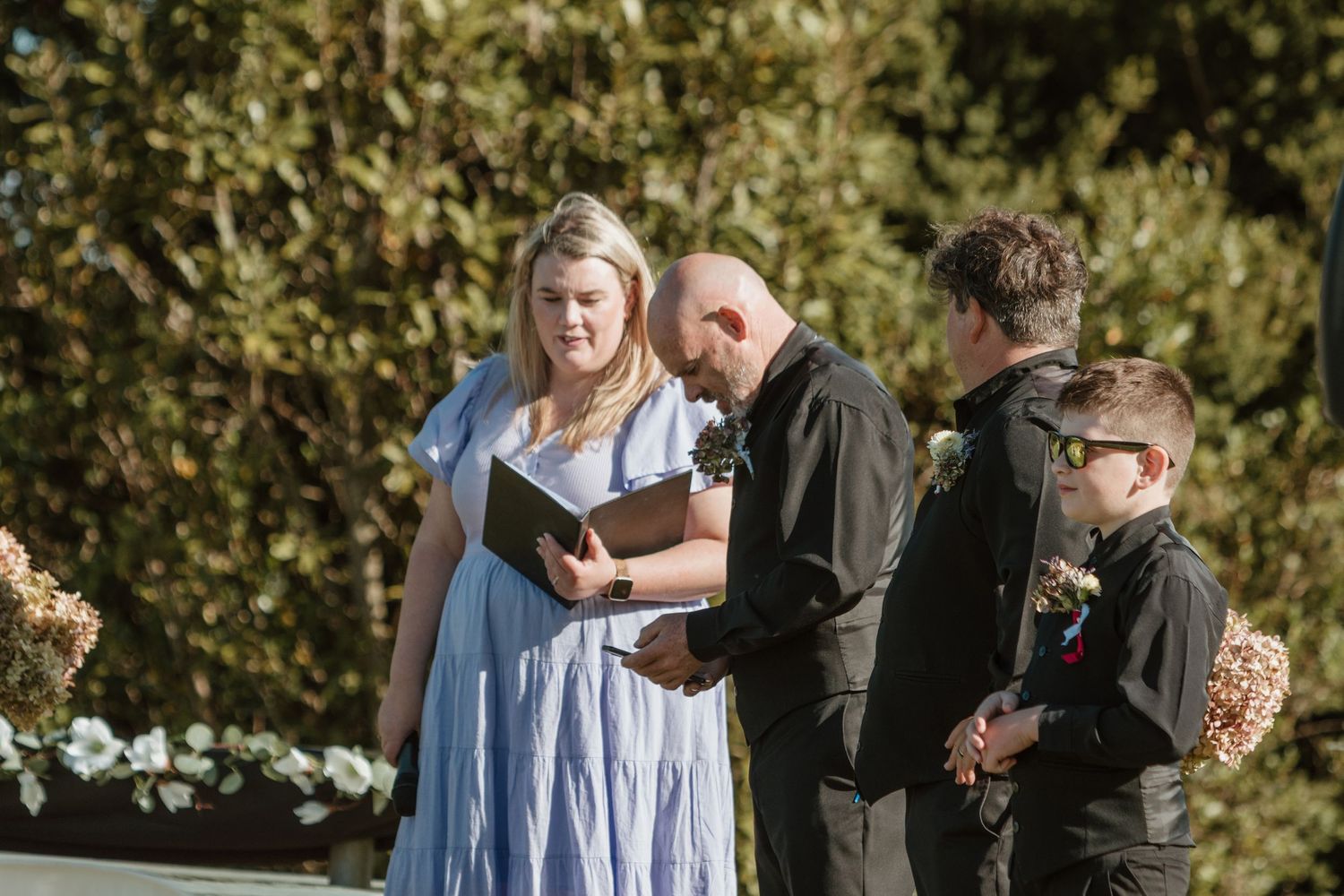 People in natural outdoor setting share joyful moments during a celebratory gathering or photoshoot.