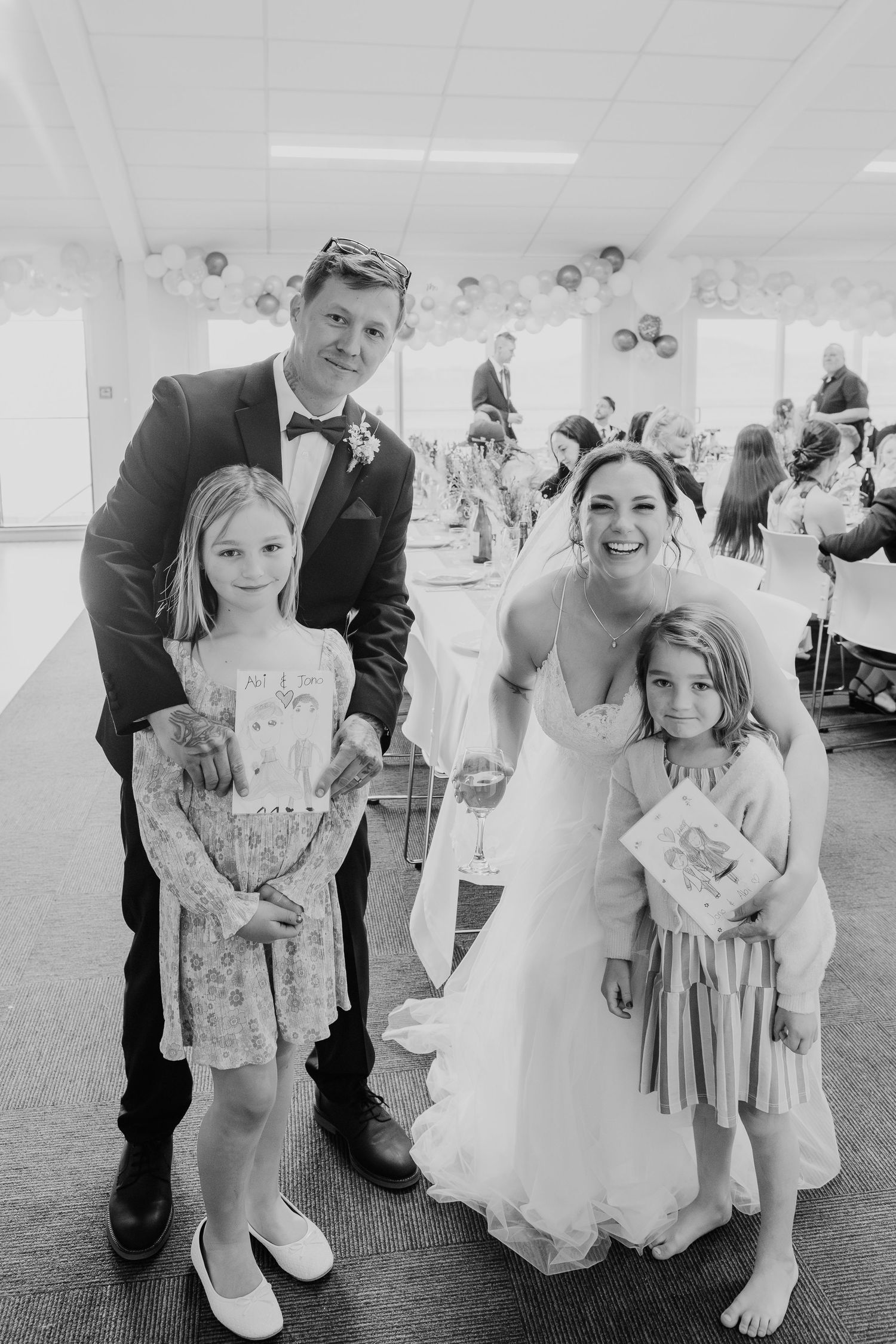 Wedding party posing during reception with children in formal attire.