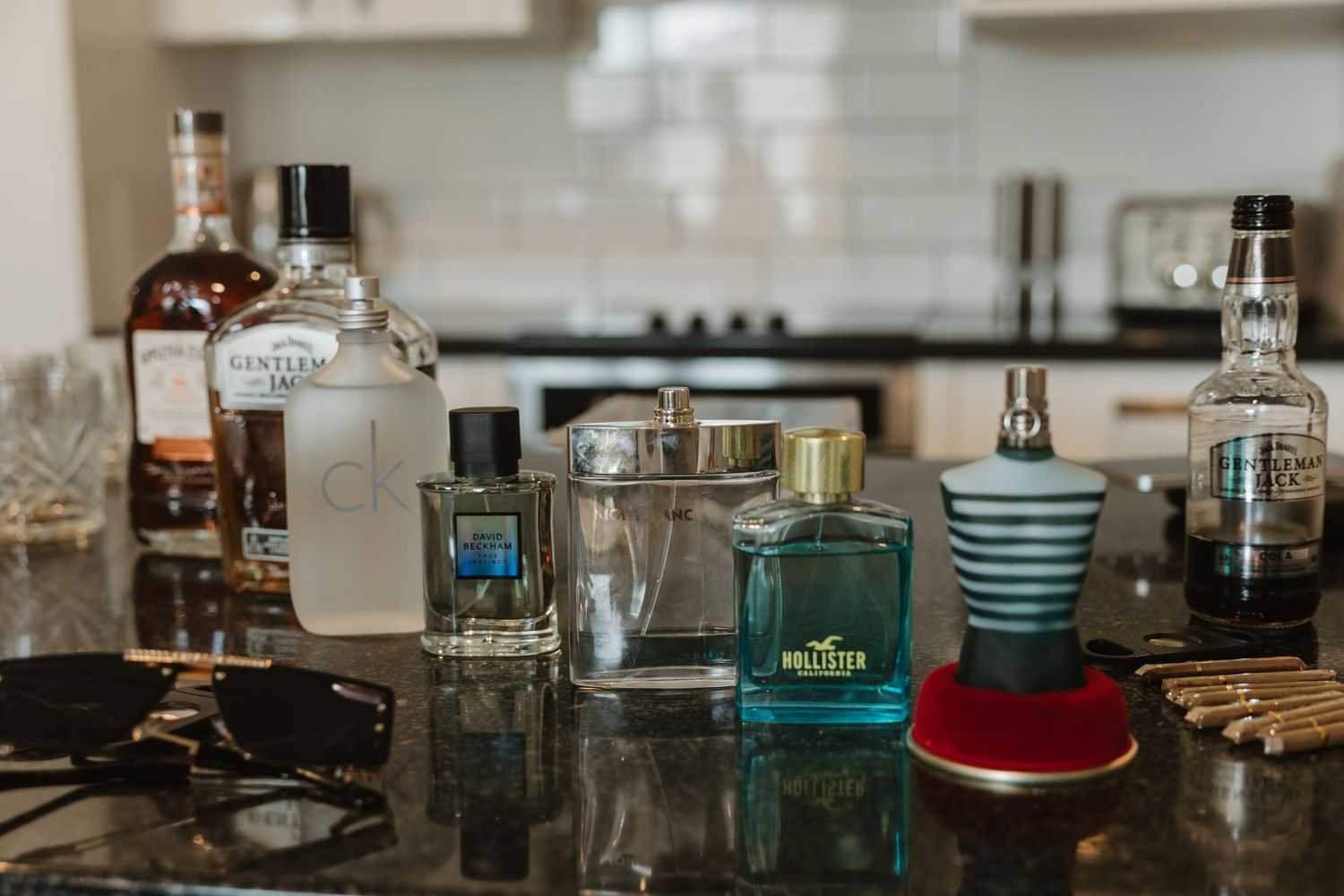 Vintage glass bottles and jars arranged on a rustic wooden shelf with antique decor items.