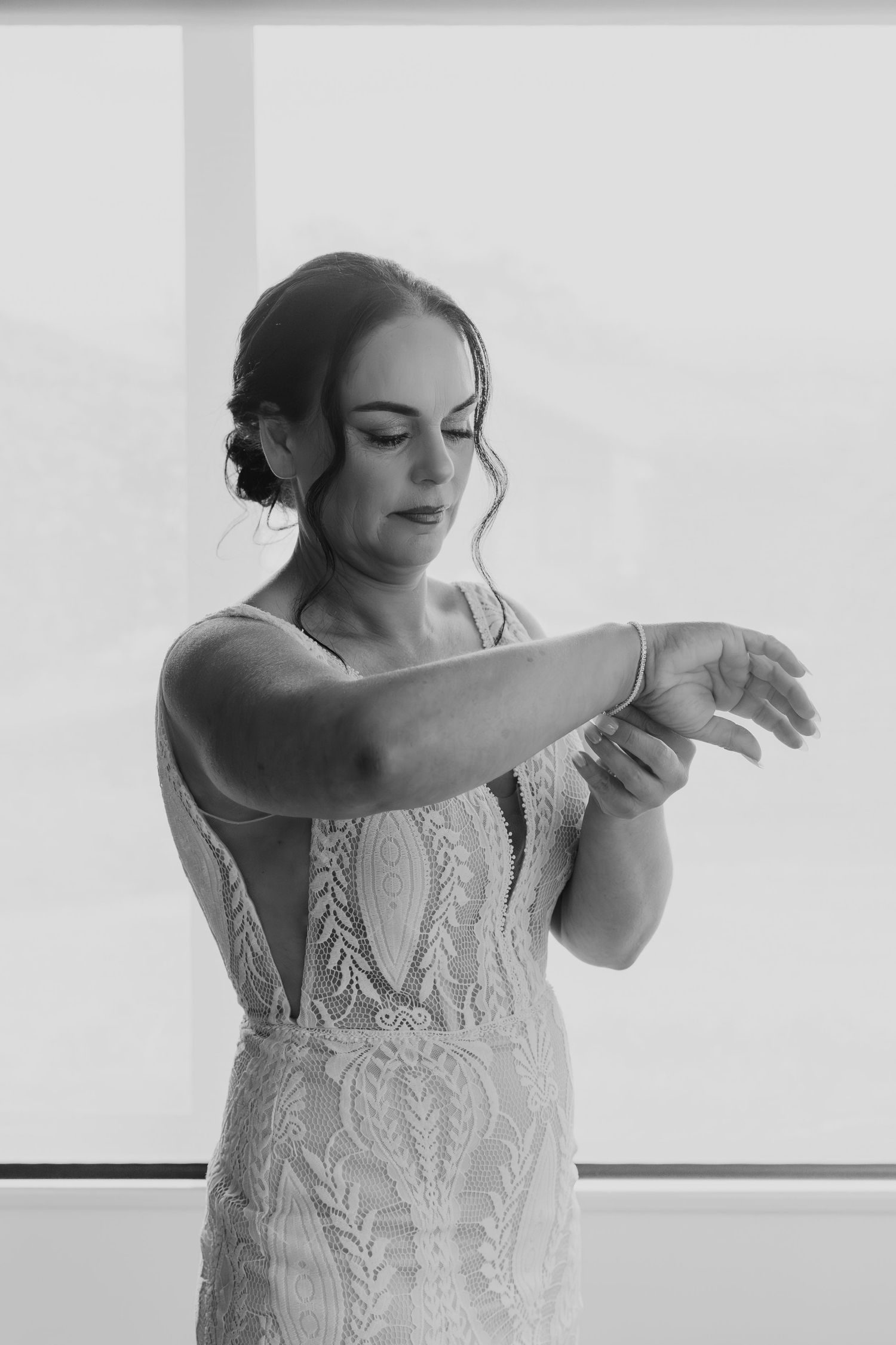 A graceful dancer in a white lace dress performs elegant arm movements in a minimalist studio setting.